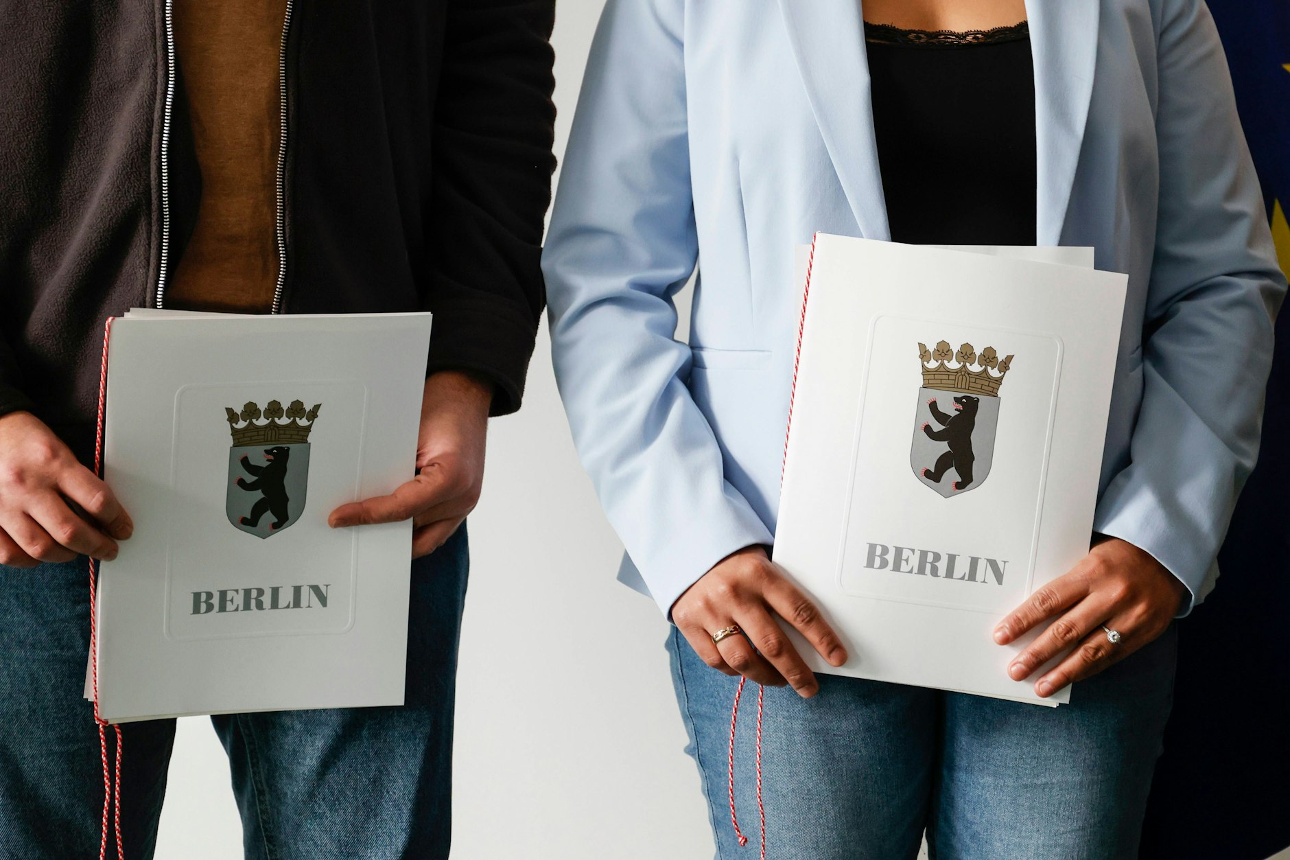 Eingebürgerte zeigen ihre Einbürgerungsurkunden nach einer Einbürgerungsfeier bei dem Landesamt für Einwanderung in Berlin 