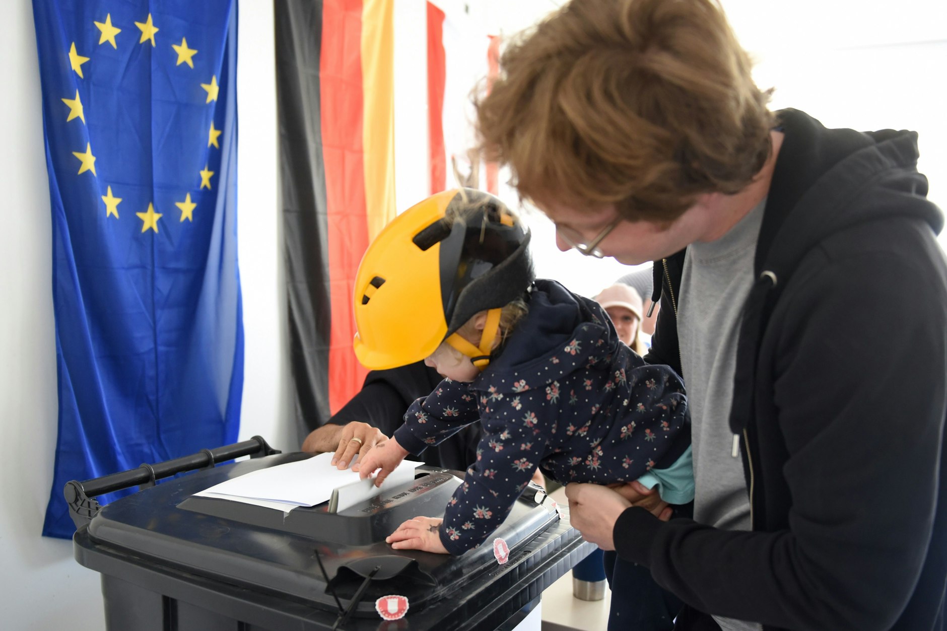 In der Rigaer Passage wirft ein Kind den Wahlzettel seiner Großmutter ein.
