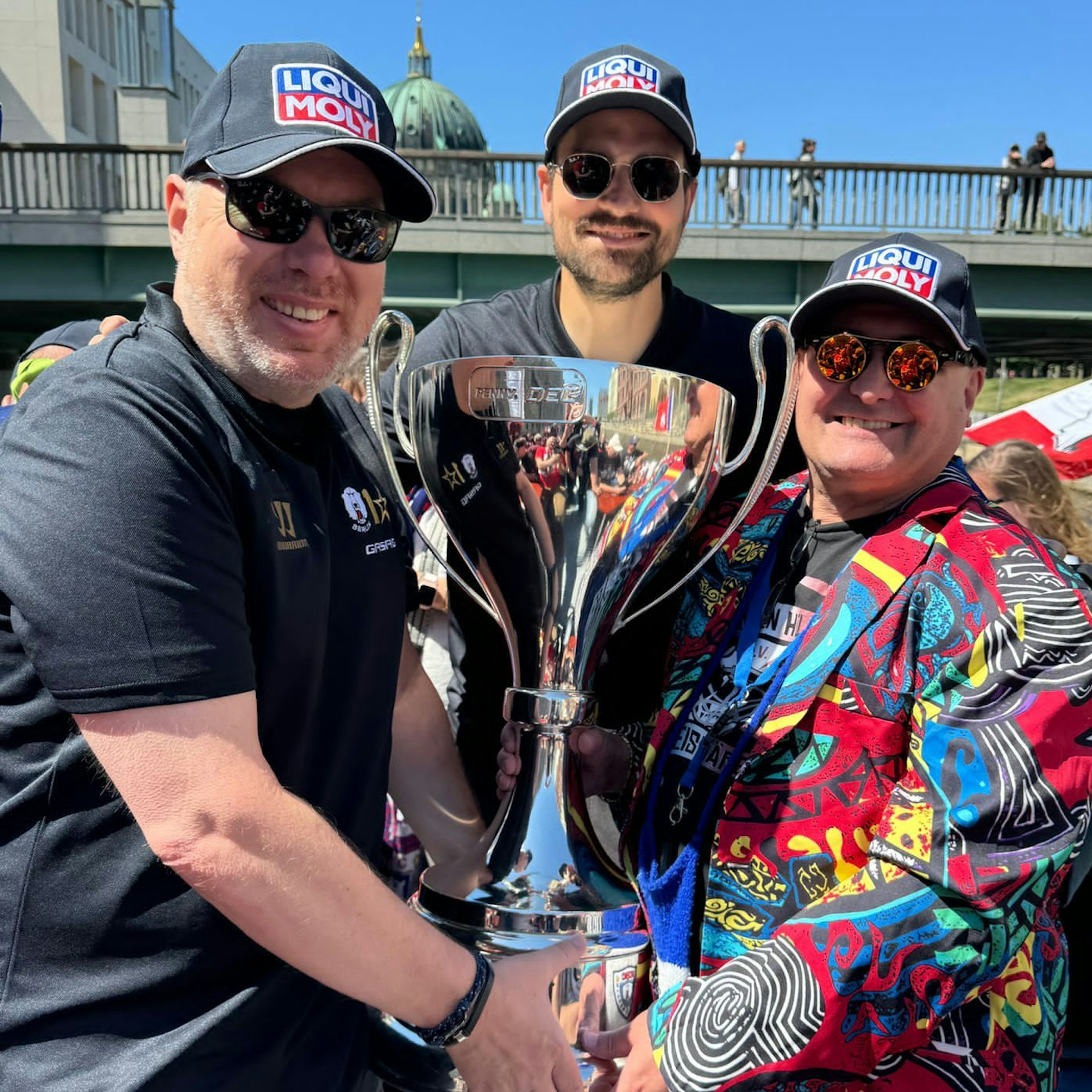 Verein, Mannschaft, Fans als Säulen des Eisbären-Erfolgs an Bord fest am Pokal vereint: EHC-Boss Thomas Bothstede, Verteidiger Marco Nowak, „Eisbären helfen Eisbären“-Chef Peter Breitenberger (v.l.).