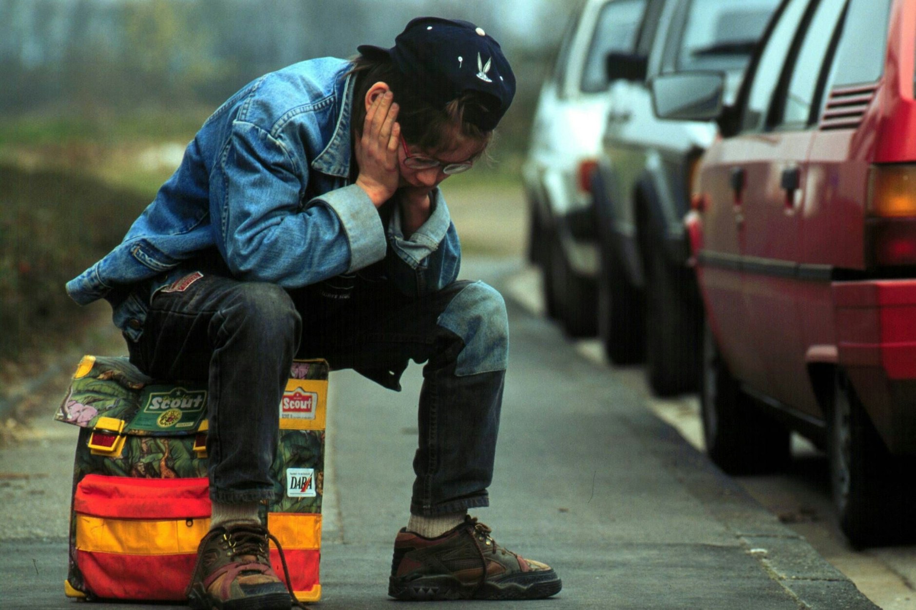 Ein Schuljunge sitzt auf seinem Ranzen. In Berlin werden Schulkinder von Stalkern terrorisiert (Symbolfoto).