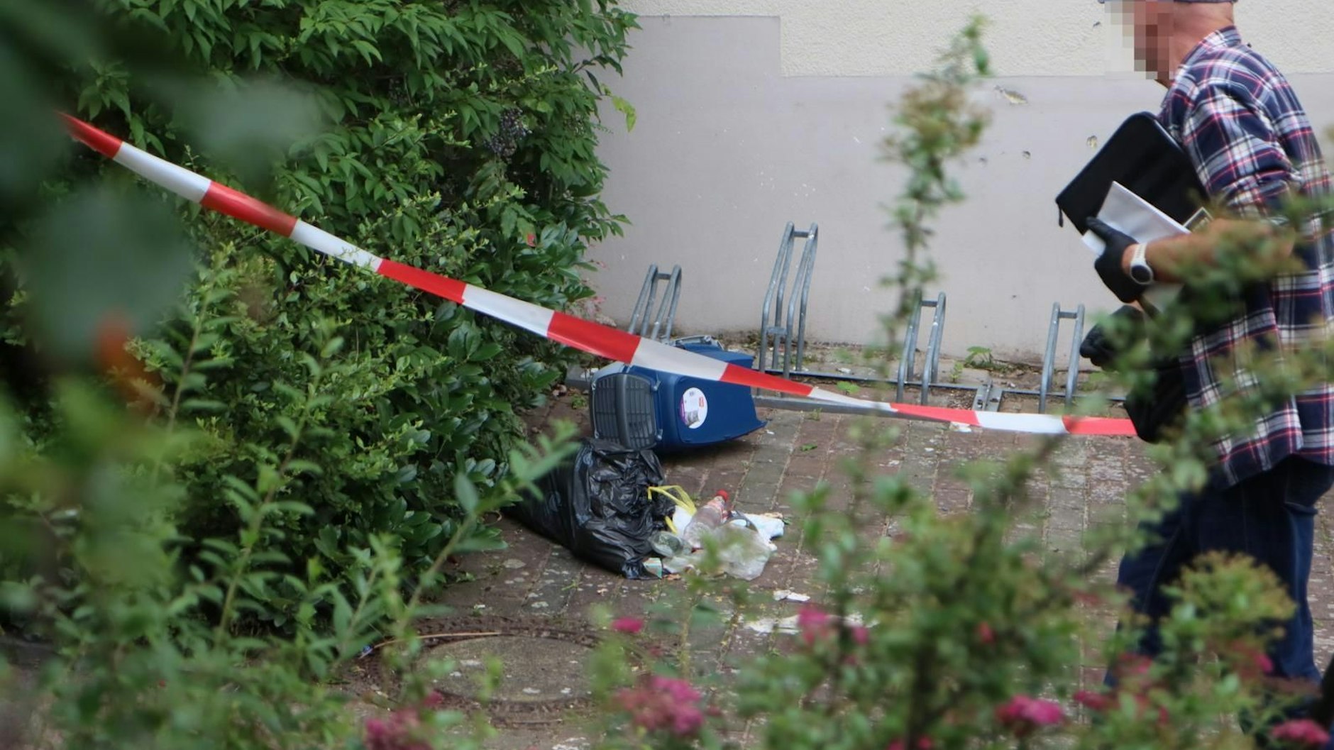 Polizei und Spurensicherung am Tatort in Altglienicke. In dieser blau-grauen Katzenbox steckte das kleine Mädchen.