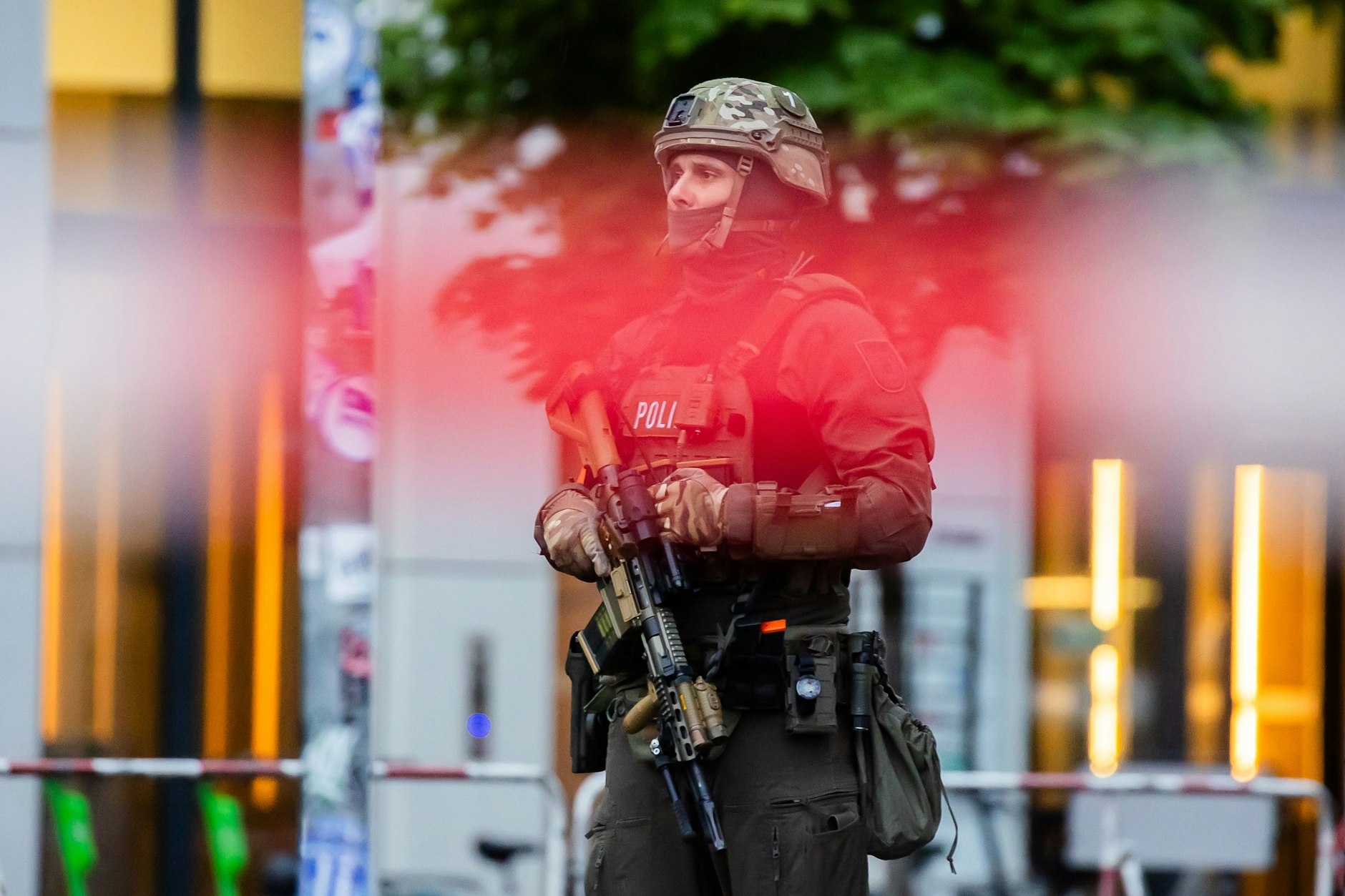 Ein schwer bewaffneter Polizist steht hinter einem Absperrband vor dem Hotel Waldorf Astoria Berlin.