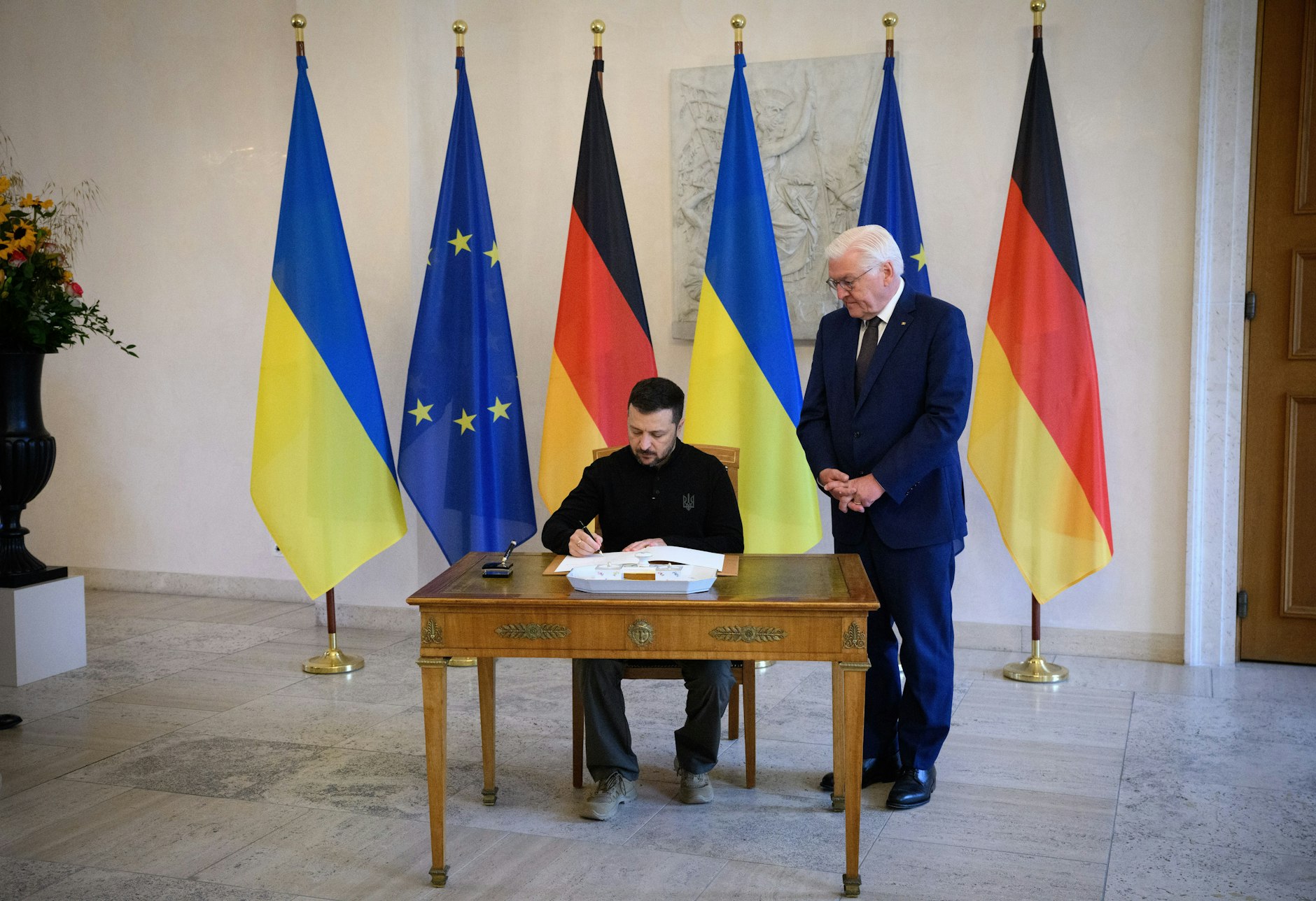 Wolodymyr Selenskyj trägt sich vor seinem Gespräch mit Frank-Walter Steinmeier im Schloss Bellevue in das Gästebuch ein.