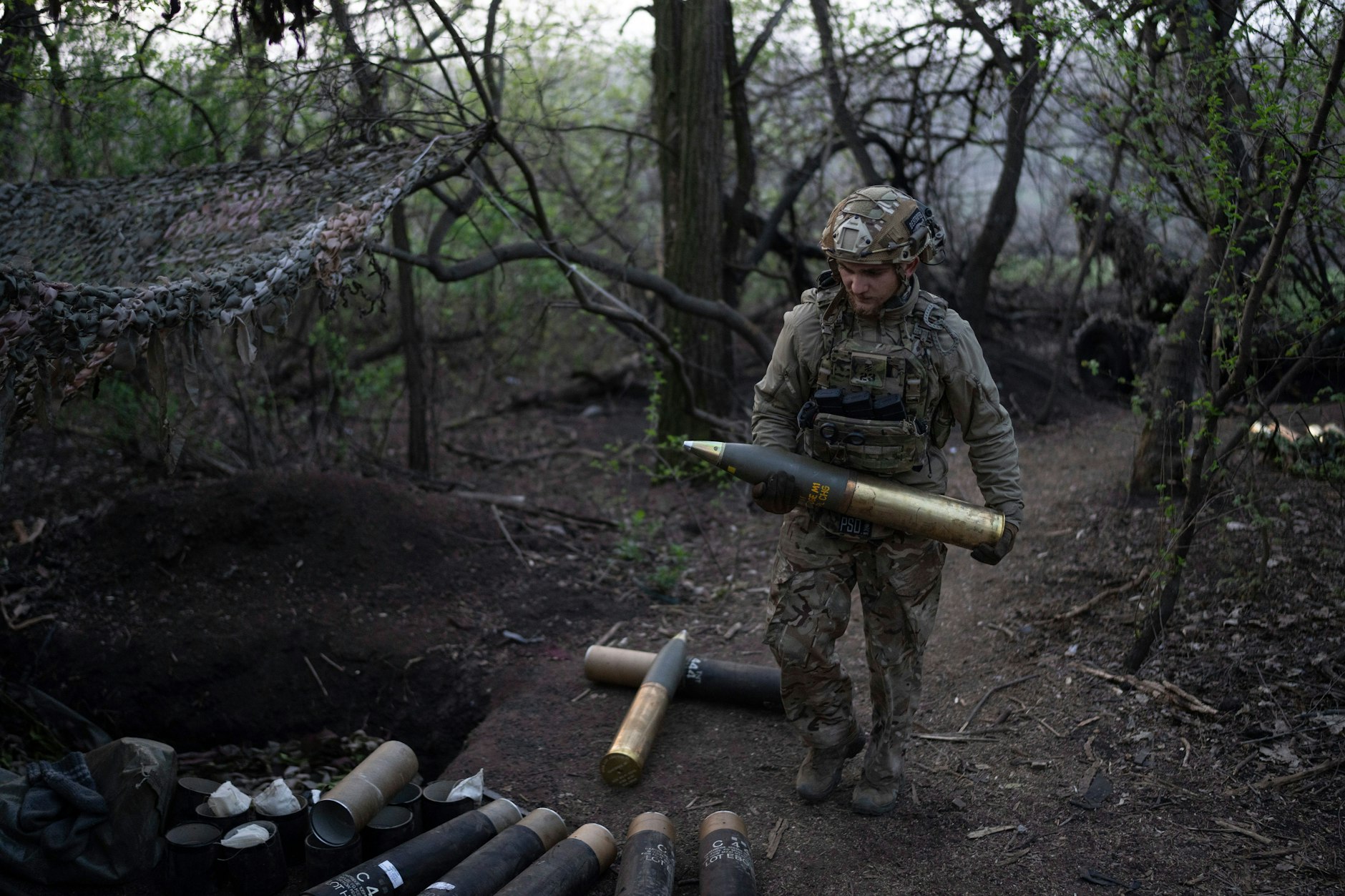 Ein Soldat der Asow-Brigade trägt eine Granate zu einer Haubitze in der Region Donezk.