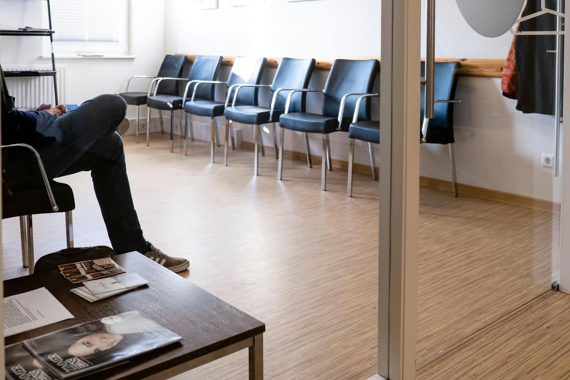 Ein Patient sitzt im Wartezimmer einer Gemeinschaftspraxis.