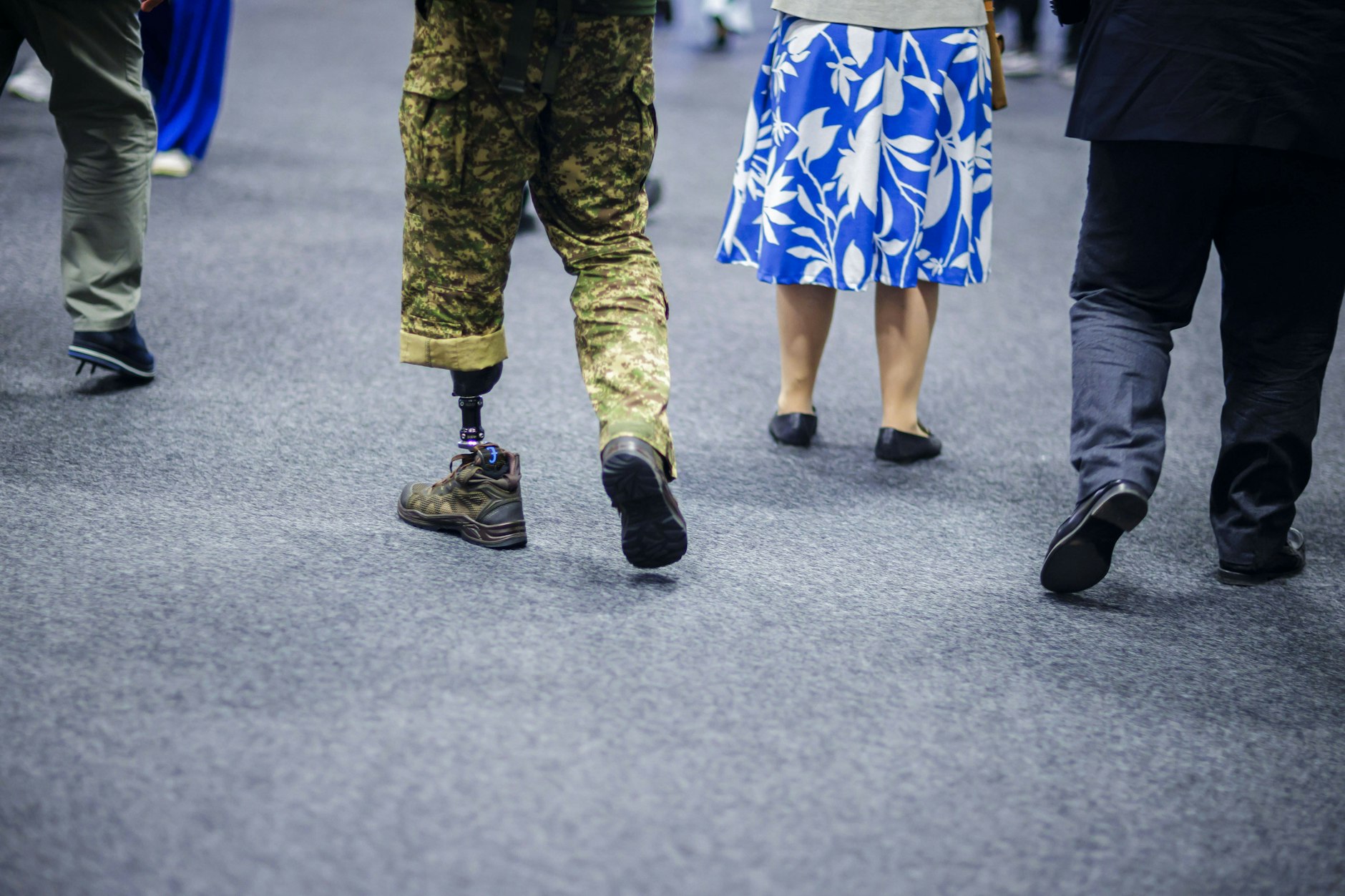 Ein ukrainischer Soldat mit einer Prothese geht während der Ukraine-Wiederaufbaukonferenz durch die Ausstellungshalle.