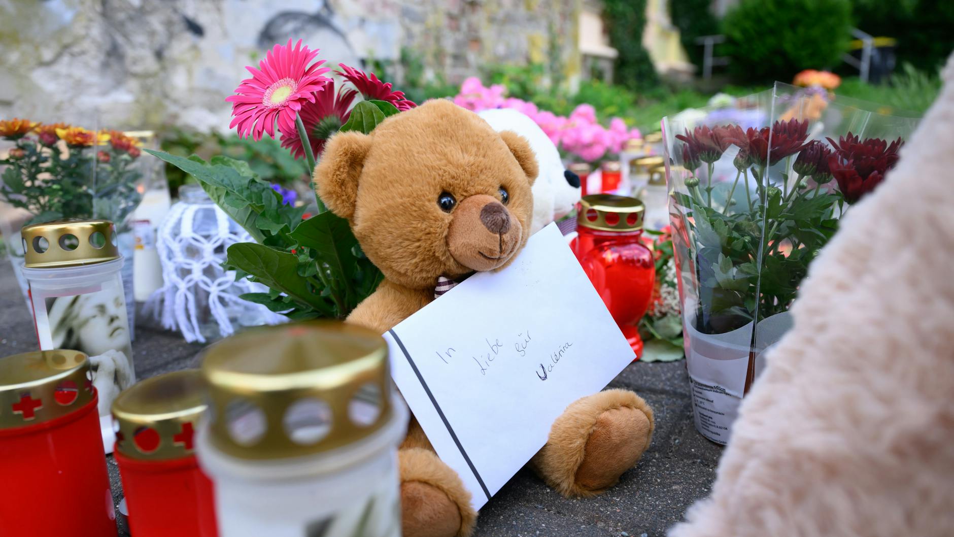 Ein Brief mit der Aufschrift „In Liebe für Valeriia“, Teddybären, Blumen und Kerzen sind in der Nähe der Wohnung des getöteten Mädchens auf dem Fußweg abgelegt. 