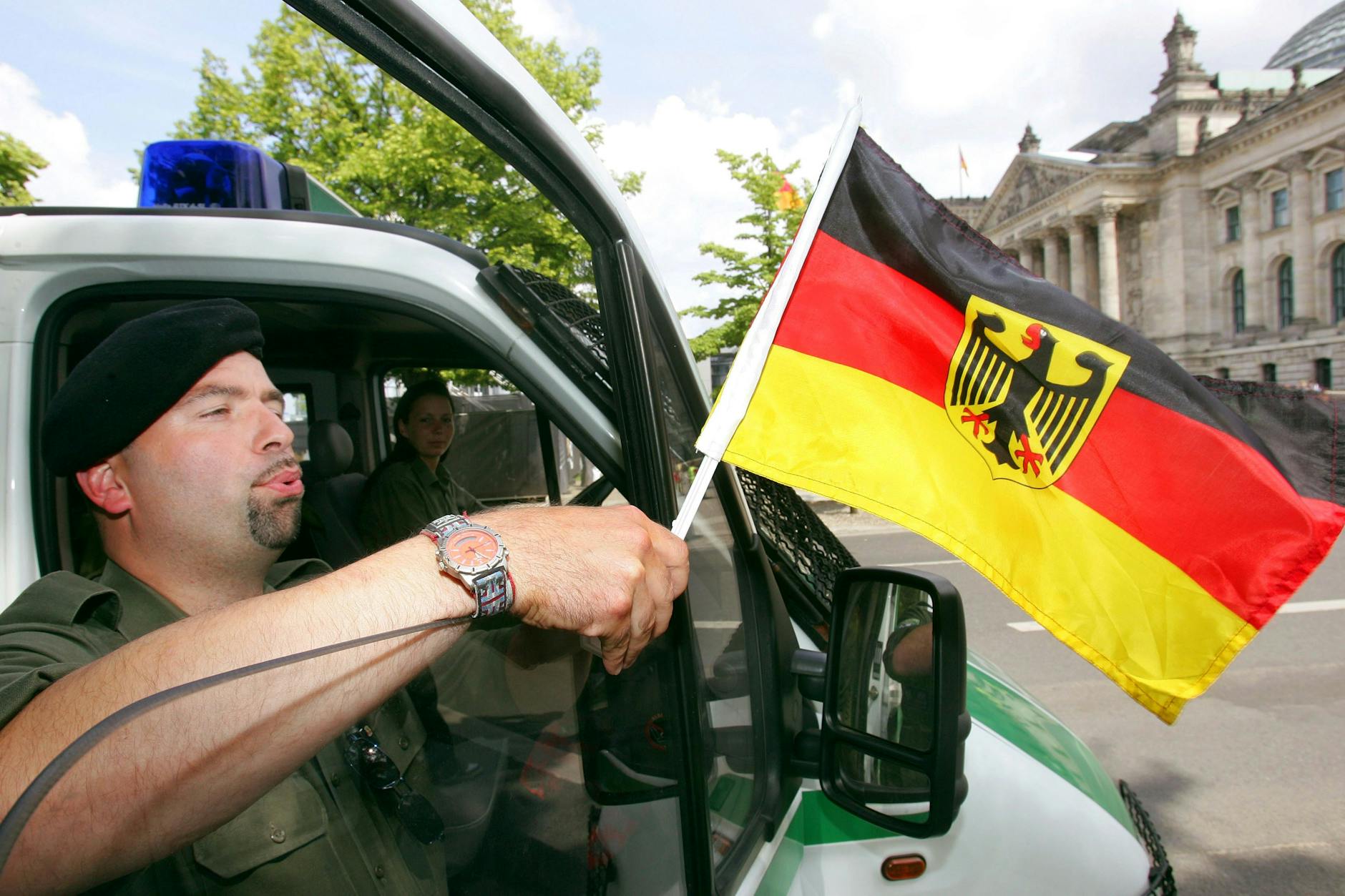 Ein Polizist mit Deutschlandflagge vor dem Berliner Reichstagsgebäude. Das war, bevor das Verbot 2006 kam.