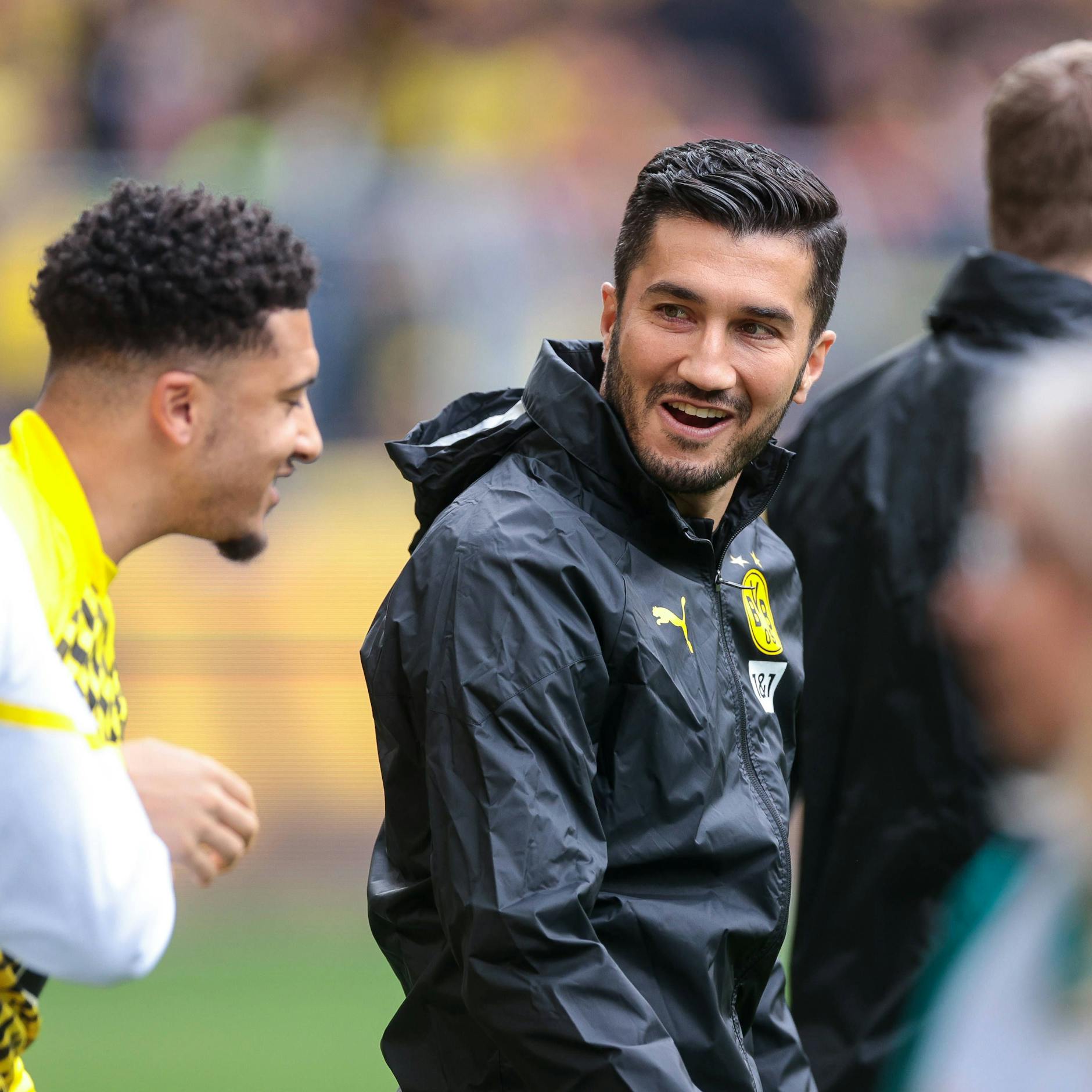 Dortmunds Trainer Nuri Sahin lacht mit Stürmer Jadon Sancho.