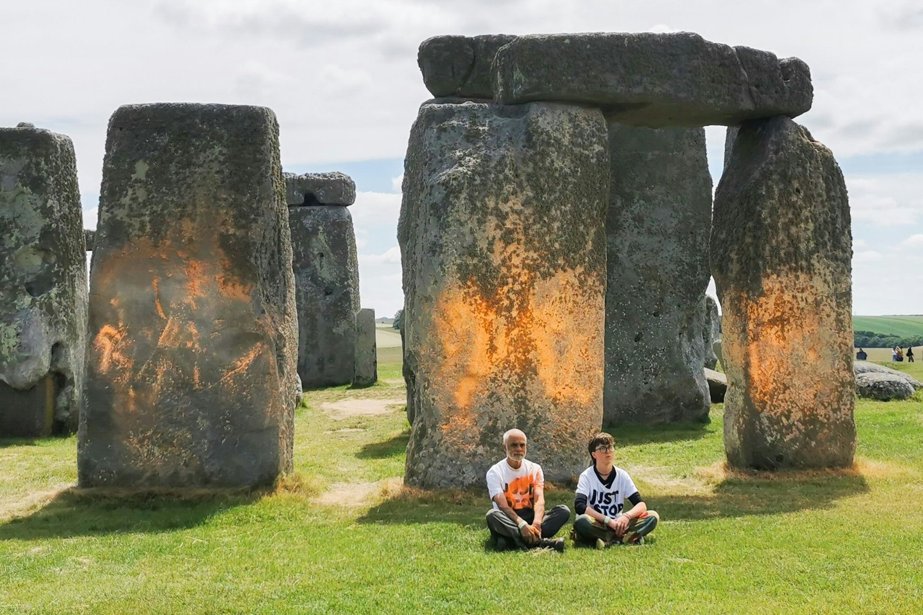 Demonstranten von Just Stop Oil sitzen vor dem Steinmonument Stonehenge.