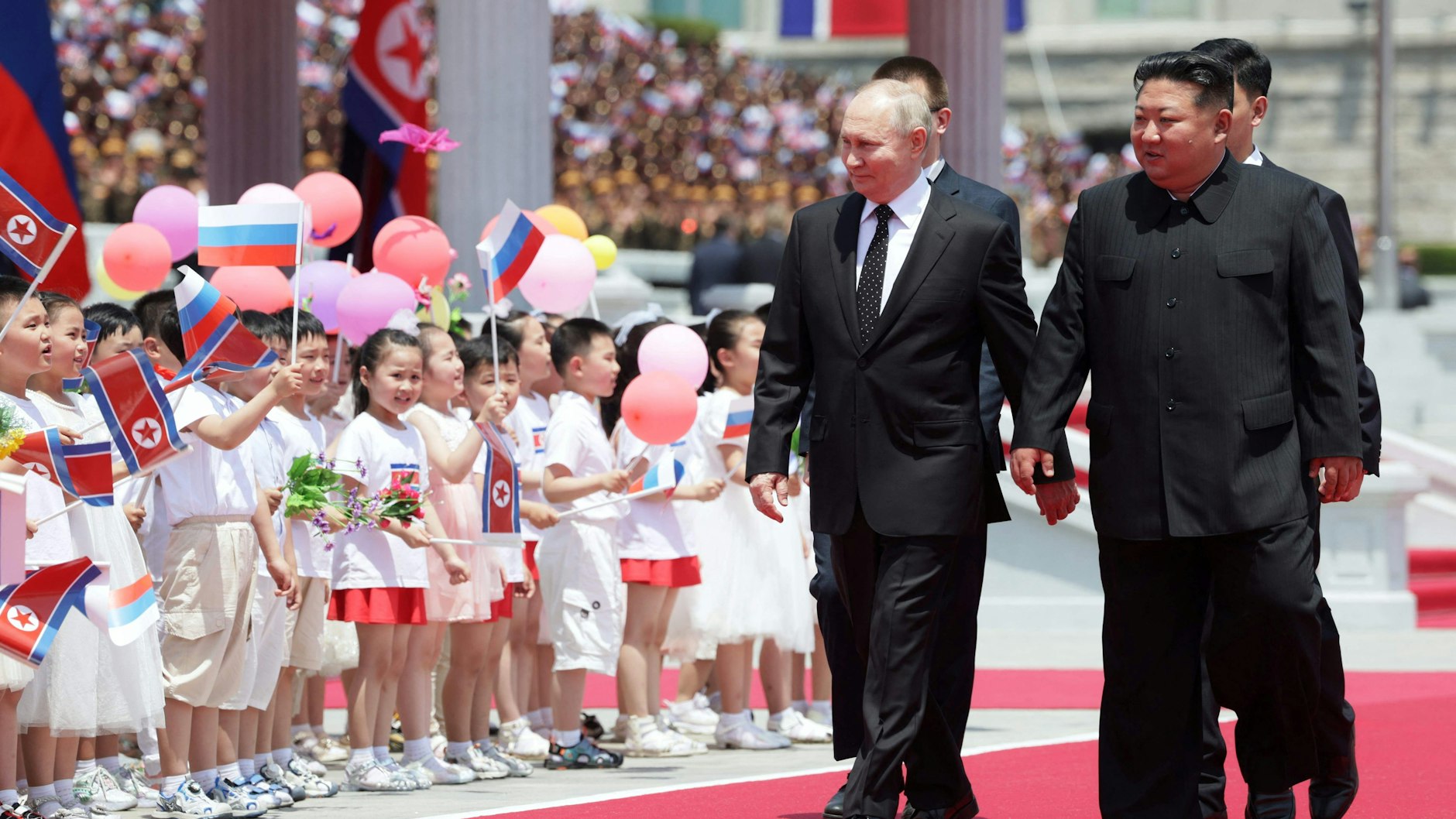 Auch Kinder durften für Putin und Kim Jong Un Fähnchen schwenken.