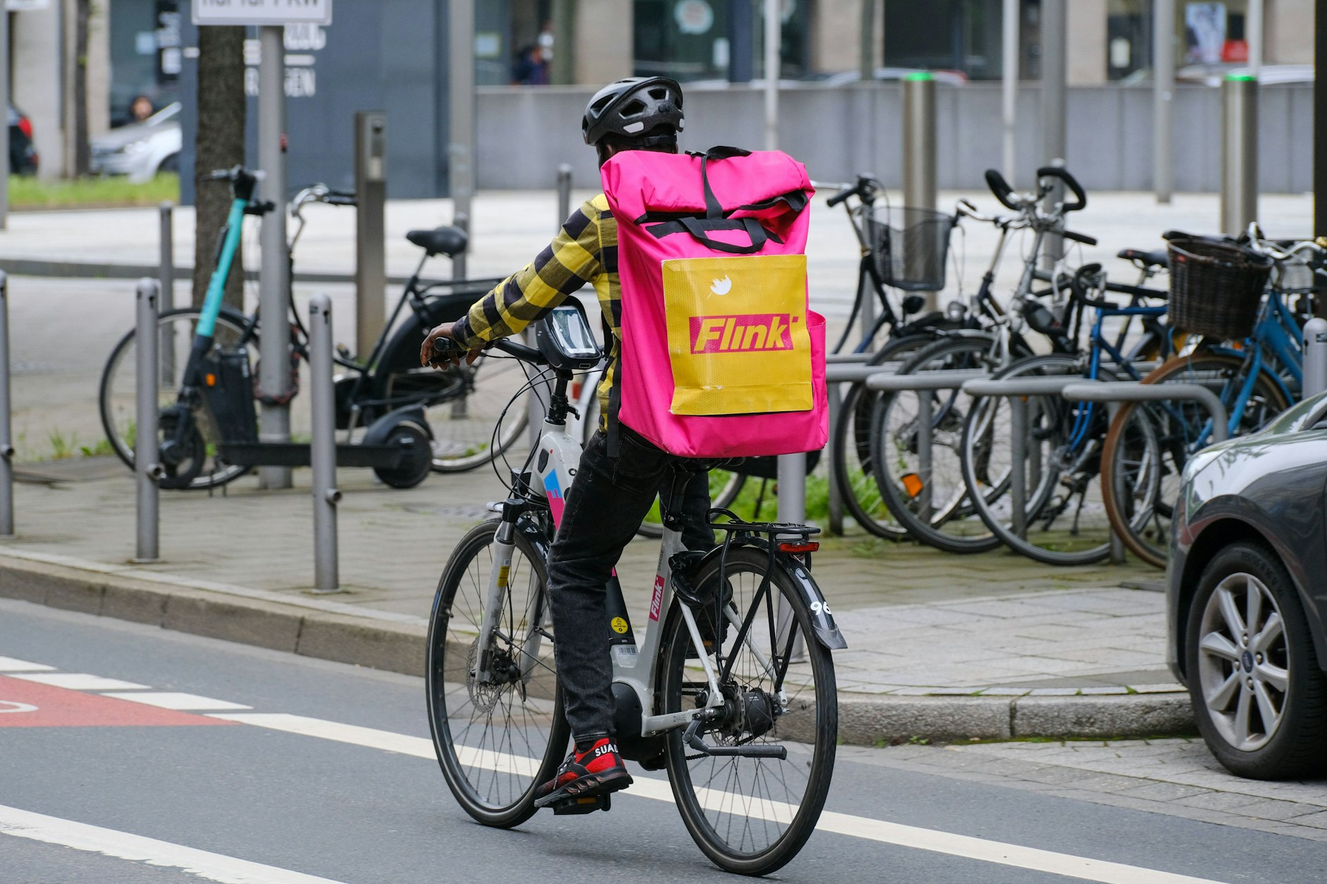 Ein Fahrer des Lieferdienstes Flink bringt Essen zu einem Kunden.