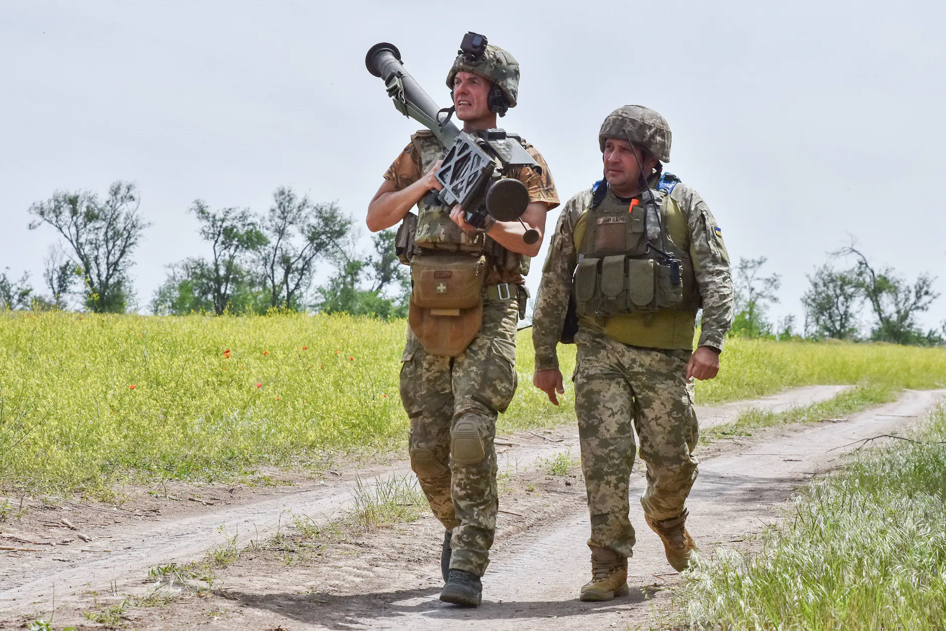 Ukrainische Soldaten laufen mit einem amerikanischen Stinger-Luftabwehrraketenwerfer in der Region Saporischschja einen Weg entlang. An der Front im Osten und Süden der Ukraine bleibt es bei der militärischen Pattsituation zwischen Moskau und Kiew.