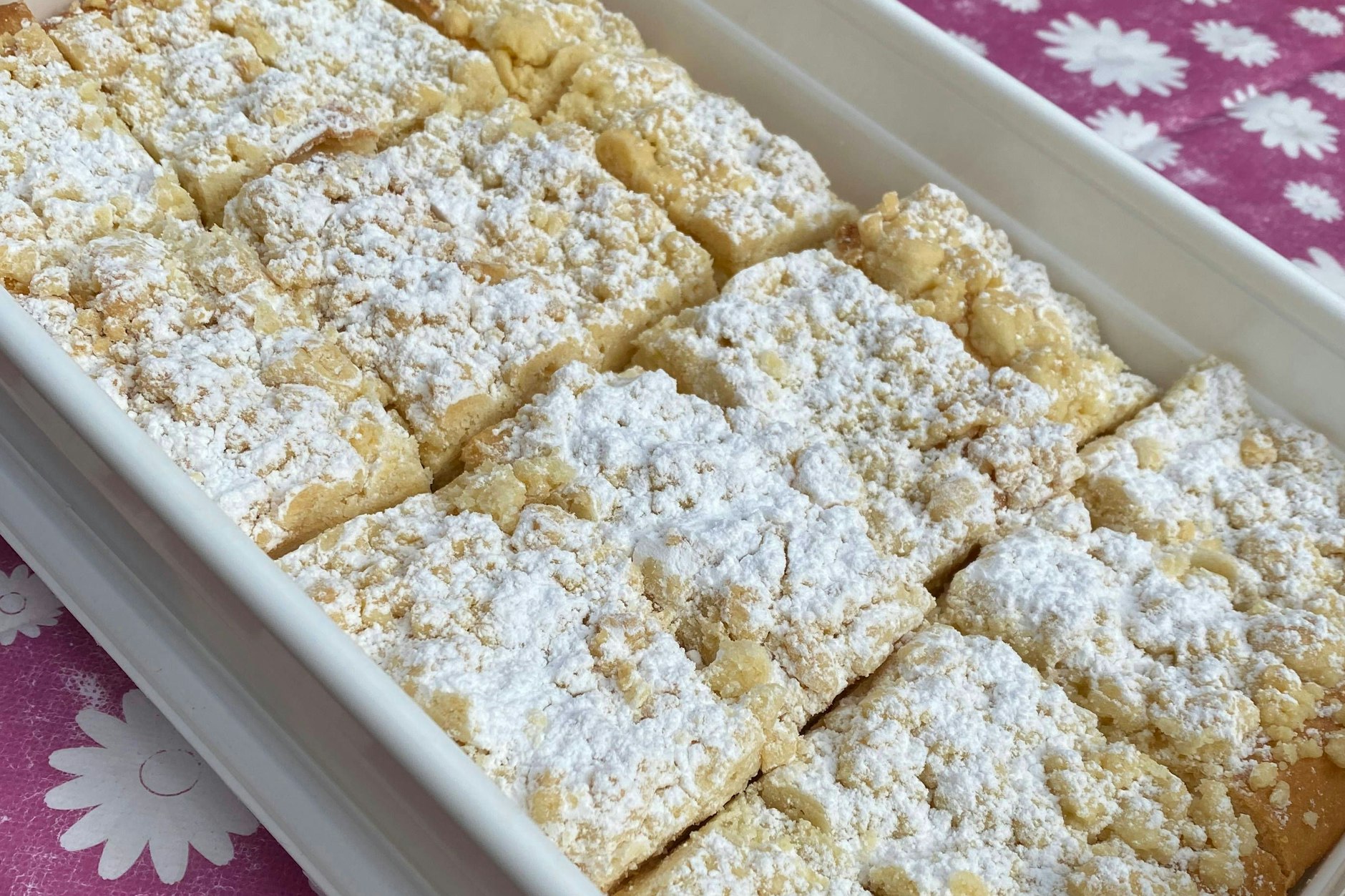 Der leckere Streuselkuchen mit Pudding nach diesem Rezept kann mit etwas Puderzucker verfeinert werden.