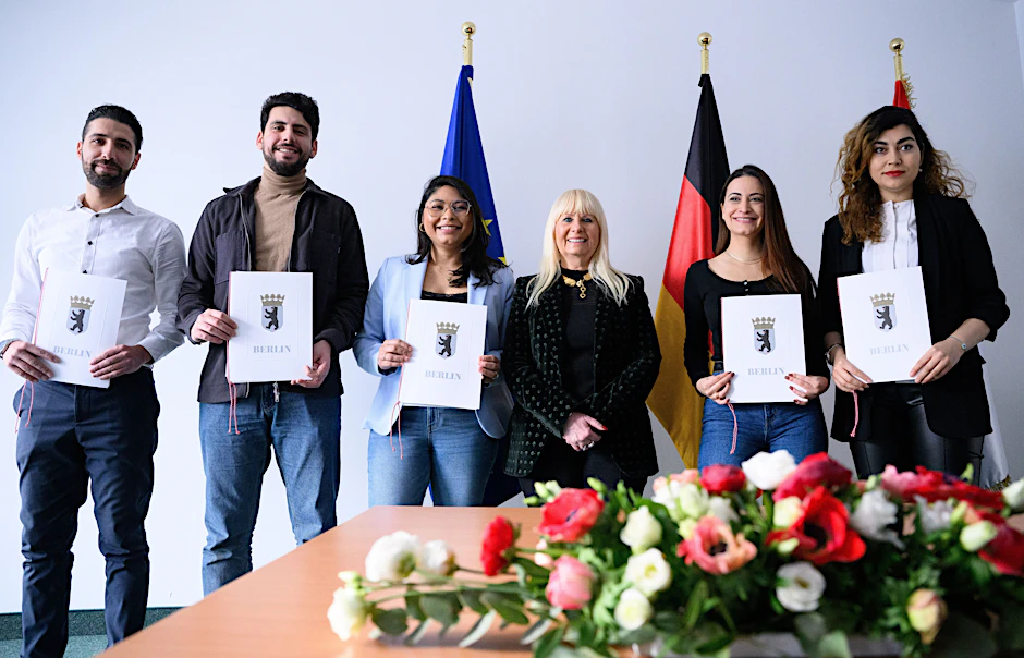 Die Berliner Innensenatorin Iris Spranger (3.v.r., SPD) lässt sich in der Zentralen Einbürgerungsstelle mit den soeben eingebürgerten Ali Badreddine (geboren im Libanon), Mohamed Kurdi (Syrien), Daysi Punzelt (Nicaragua), Gabriela Holzman (Brasilien) und Mahdieh Hashemi (Iran; v.l.n.r.) fotografieren.