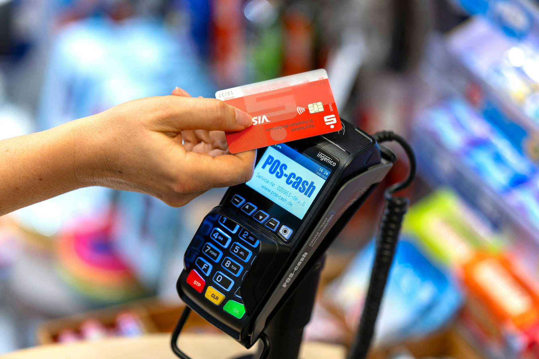 Eine Frau zahlt bargeldlos und per Funk mit einer EC-Karte an einem Kartenterminal.
