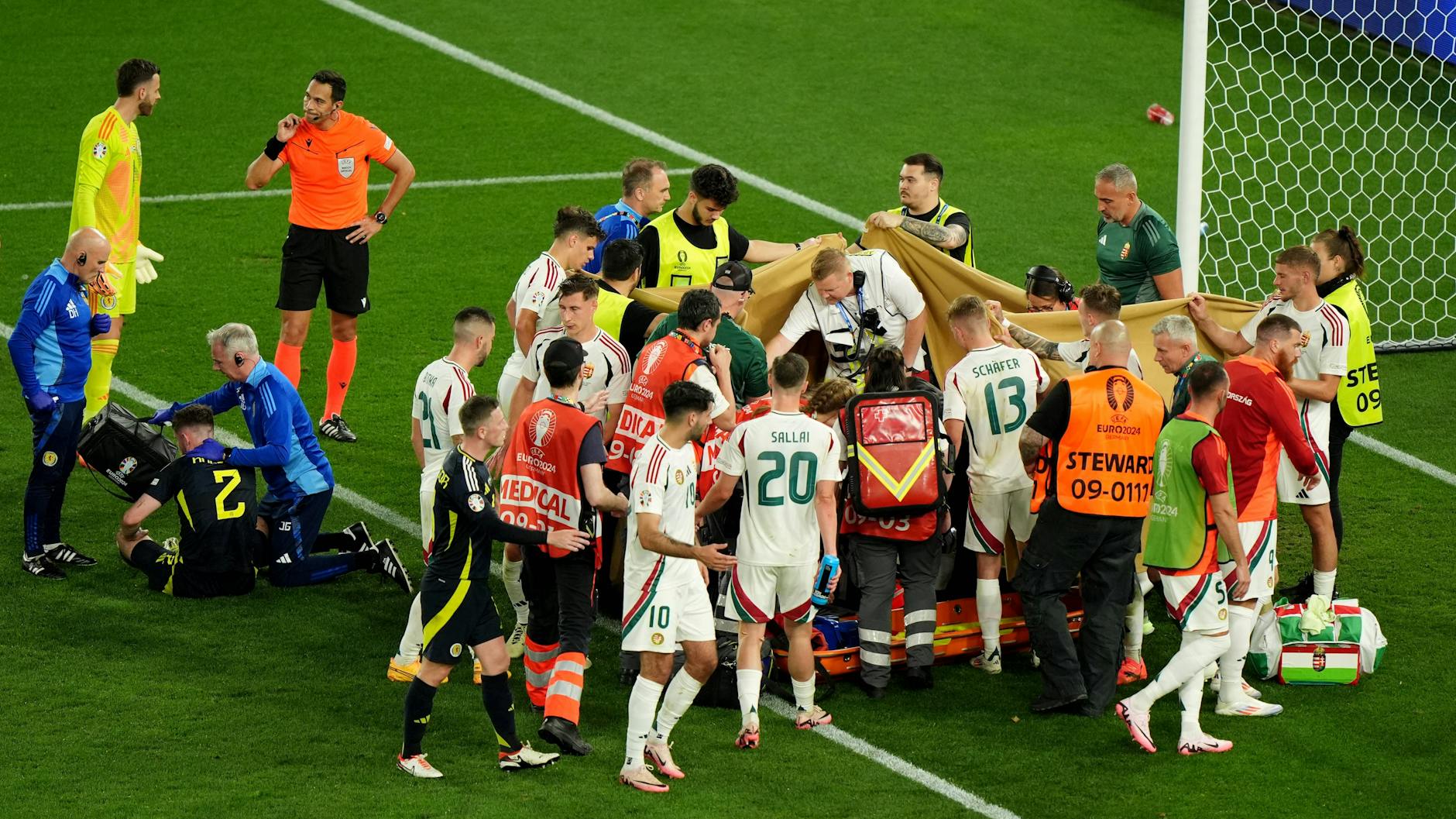 Nach dem Zusammenprall wird Ungarns Barnabas Varga hinter einem Sichtschutz behandelt.