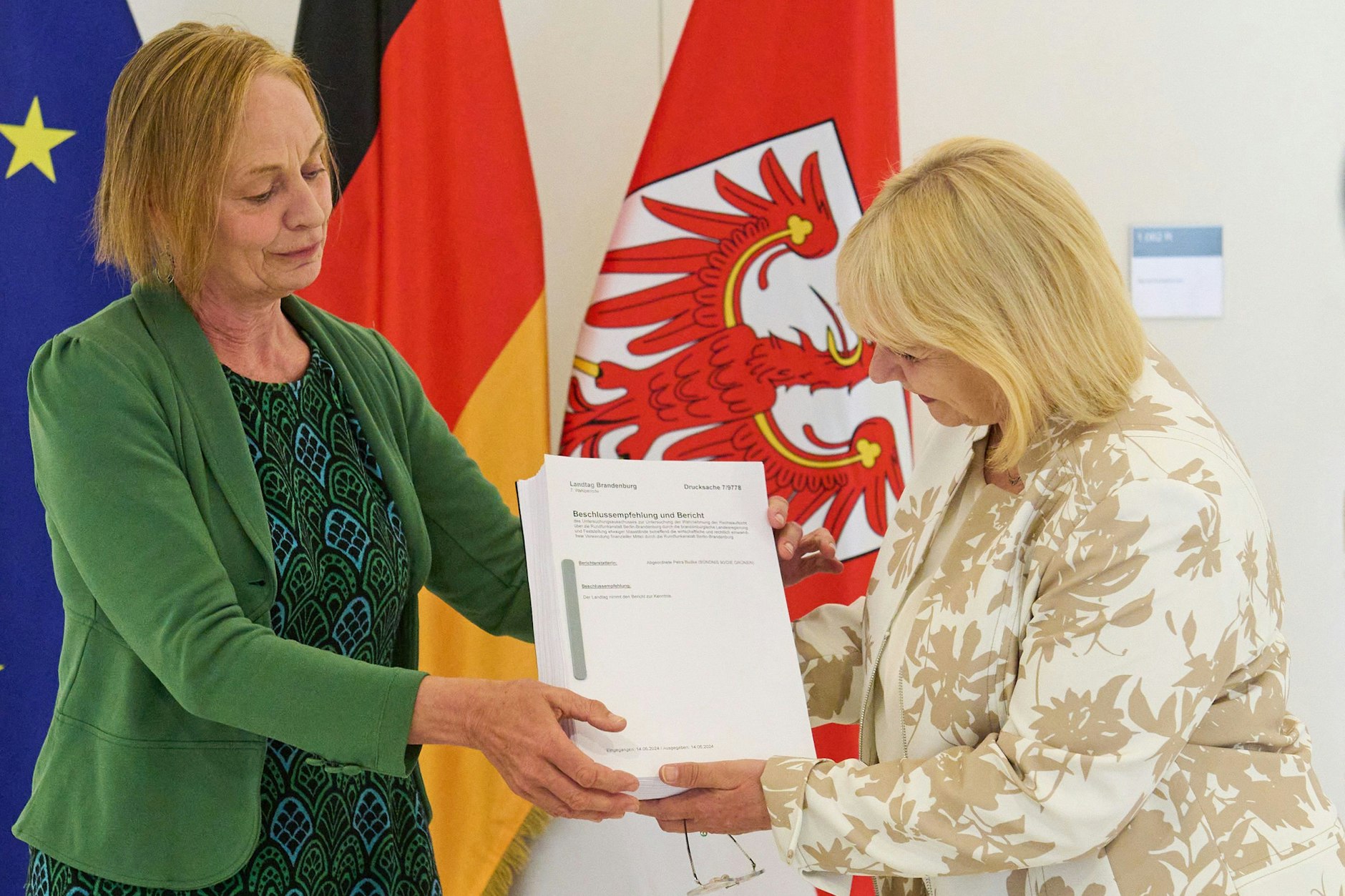 Die Vorsitzende des RBB-Untersuchungsausschusses des Brandenburger Landtags, Petra Budke (Bündnis 90/Die Grünen, l.), übergibt den Abschlussbericht des RBB-Untersuchungsausschusses an die Landtagspräsidentin Ulrike Liedtke (SPD, r.) in Potsdam.