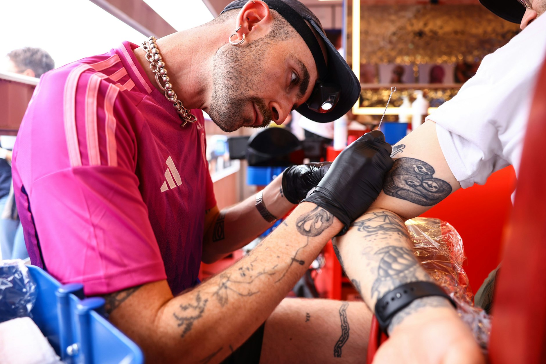 Enaitz Greaney, 30, Tattoo-Artist, tätowiert auf der Fanmeile dem 31-jährigen Max ein Schachbrettmuster auf den Arm.