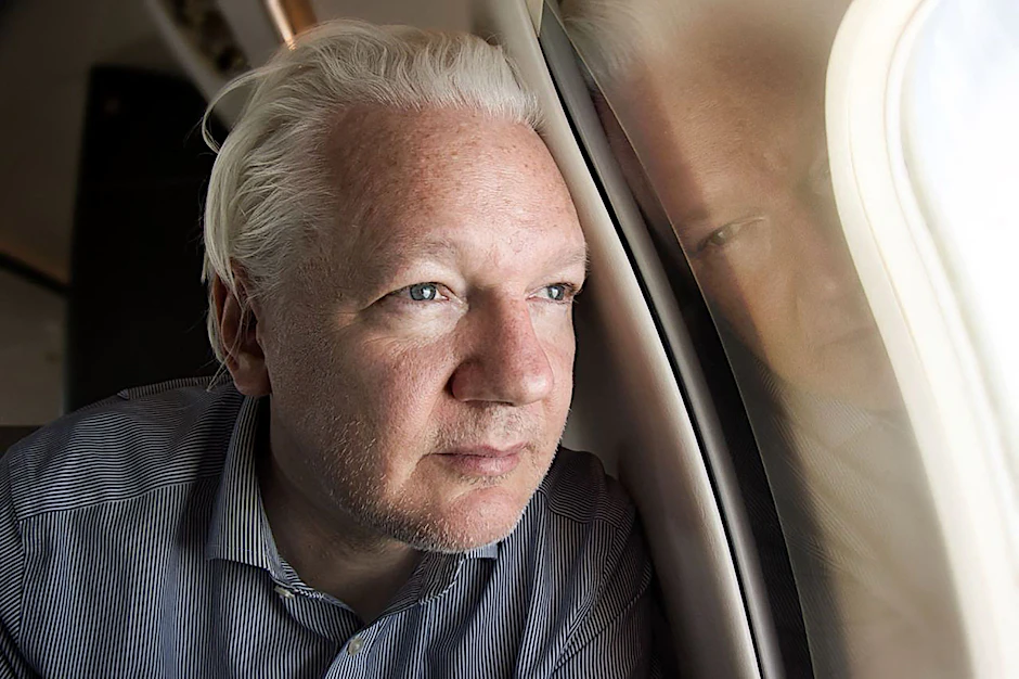 Julian Assange schaut aus dem Fenster des Flugzeugs auf der Reise von London nach Bangkok. Das Bild hat Wikileaks am 25. Juni über X geteilt.