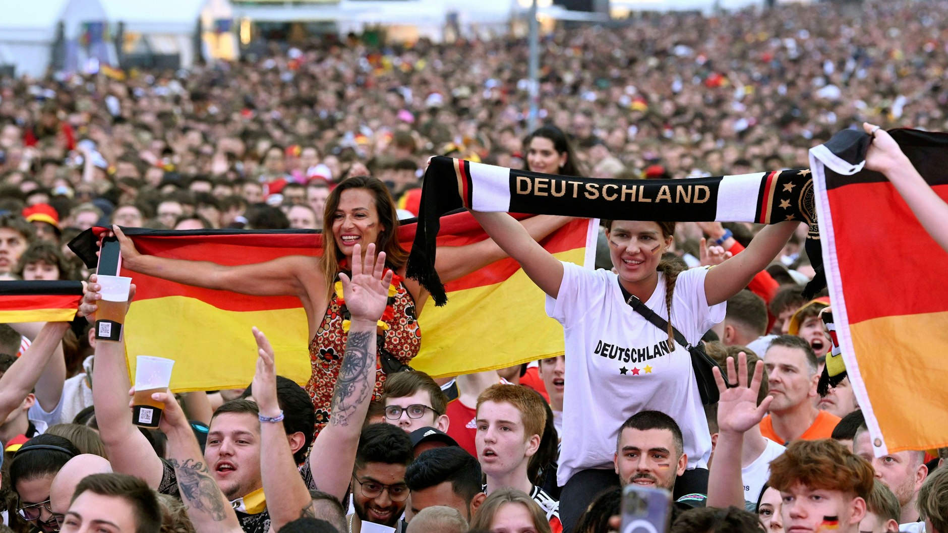 Fußballfans jubeln und feiern auf der Fanmeile zur Fußball-EM in Berlin.