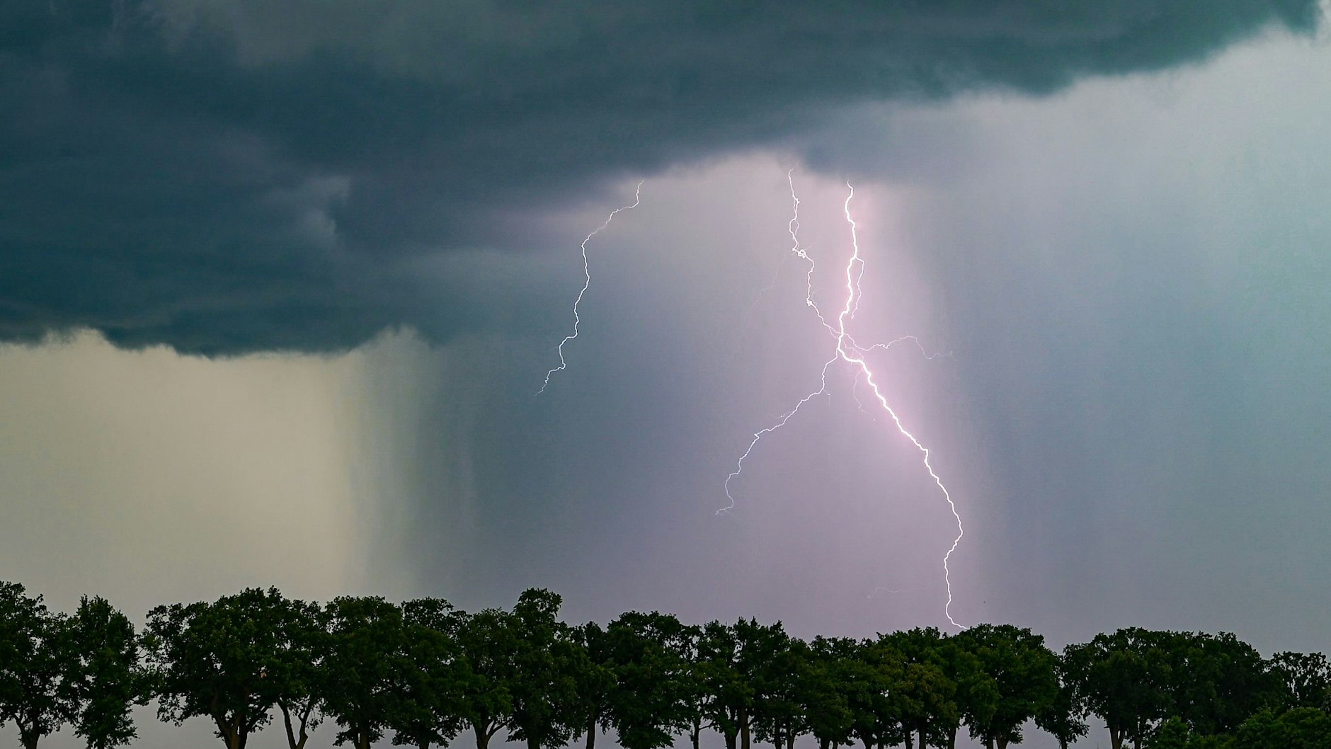 Ein Blitz leuchtet am späten Abend über Brandenburg. Aktuell gibt es wieder überall Gewitter.