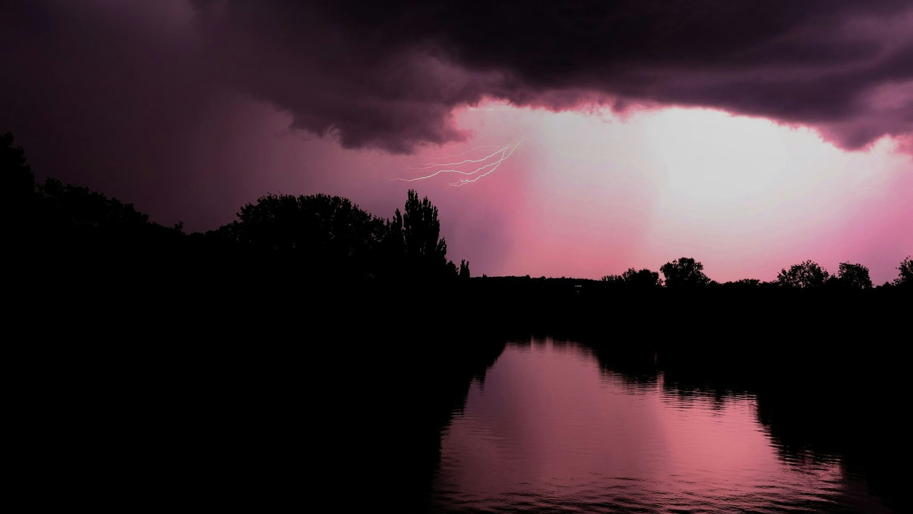 Ein nächtliches Unwetter erleuchtet den Himmel über dem Main bei Würzburg. 