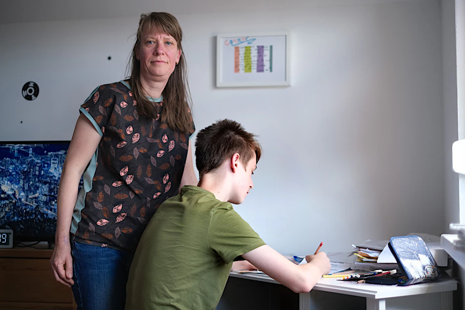 Connor sitzt am Schreibtisch. Der 13-Jährige aus Berlin-Neukölln möchte nur von hinten fotografiert werden. Seine Mutter, Anke Pohl, hilft ihm beim Lernen.
