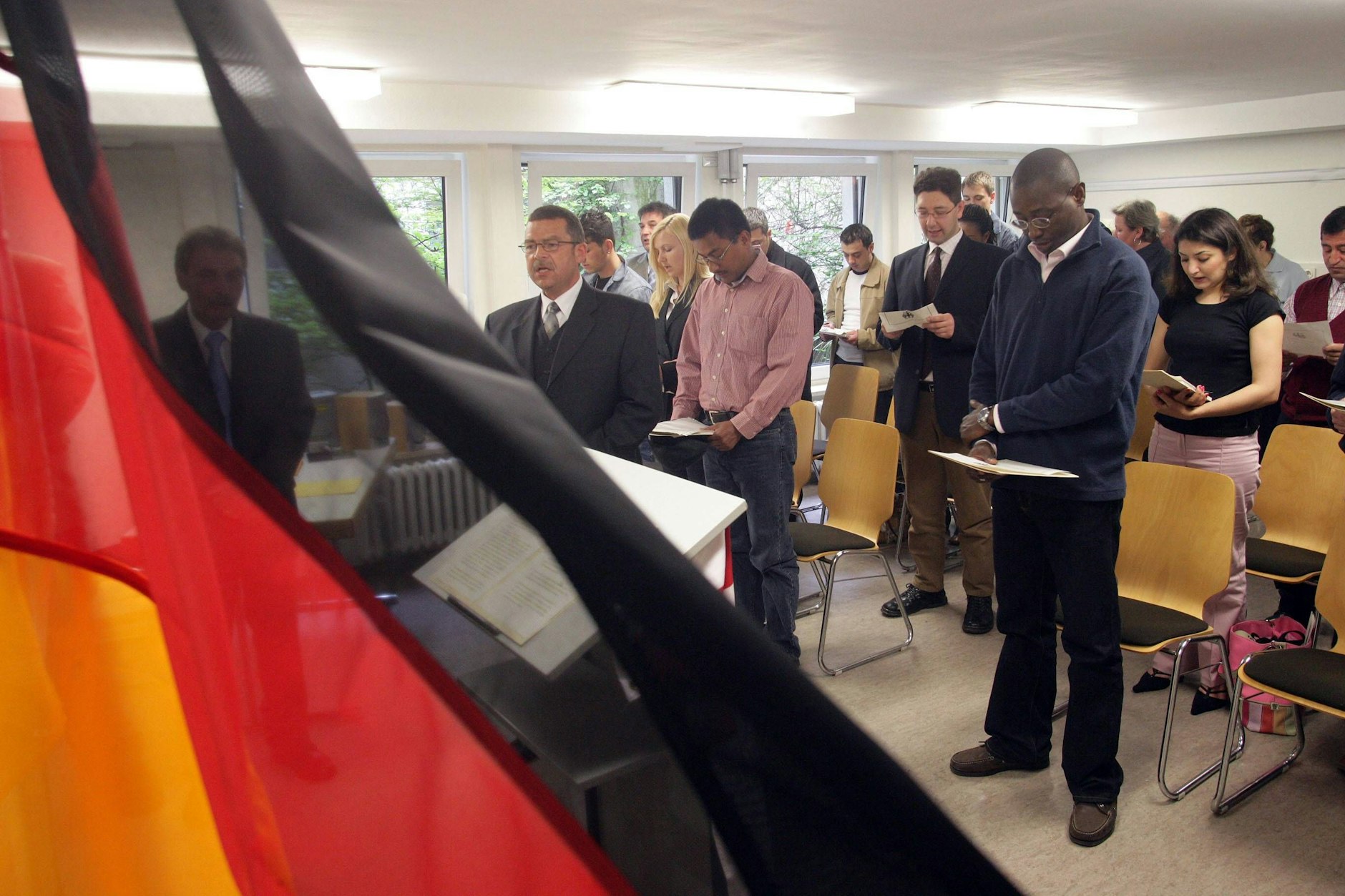 Einbürgerungsfeier – frisch Eingebürgerte singen die deutsche Nationalhymne. (Symbolbild) 