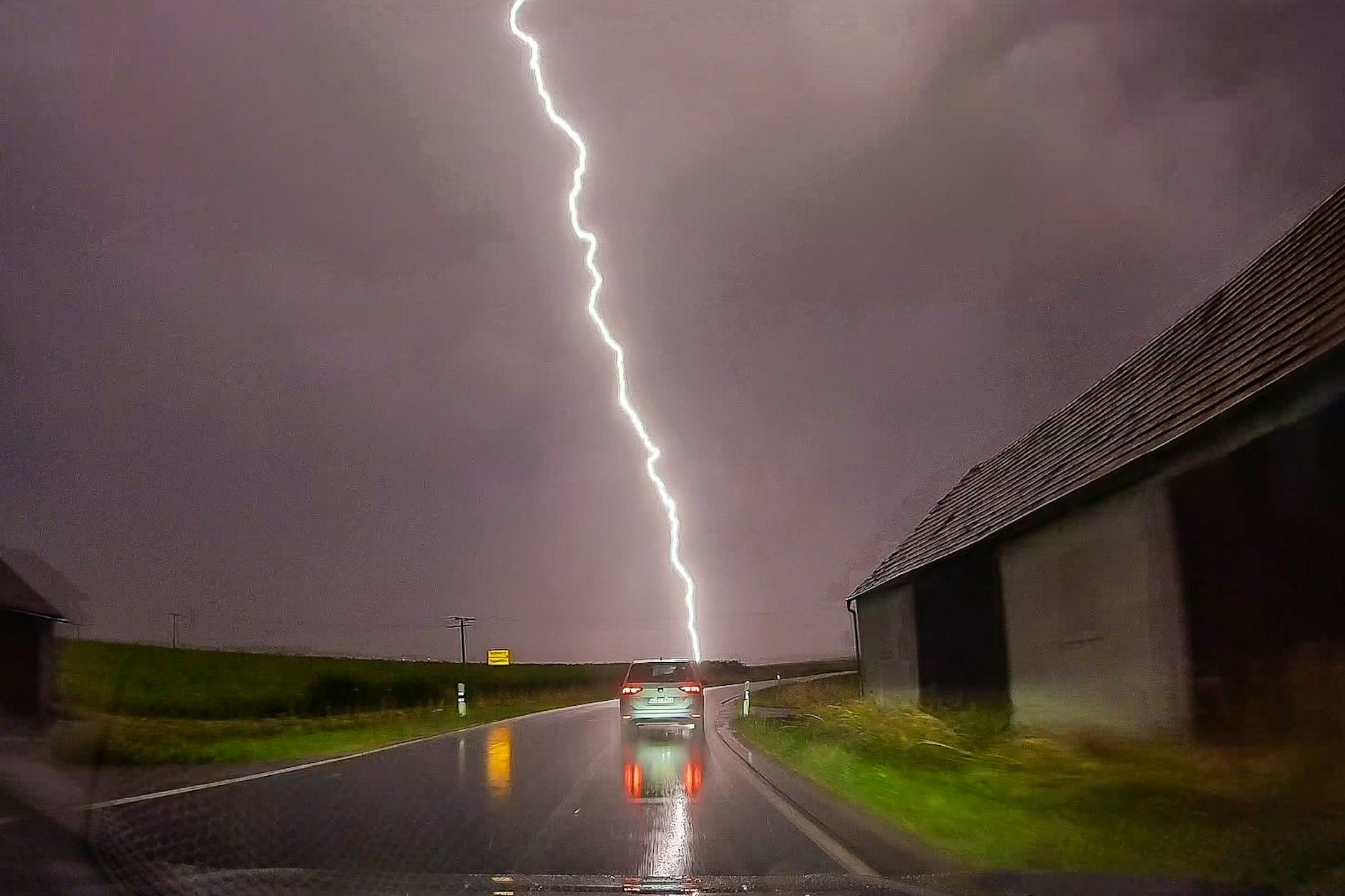 Ein Blitz schlägt in Bayern am Rande einer Straße ein. 