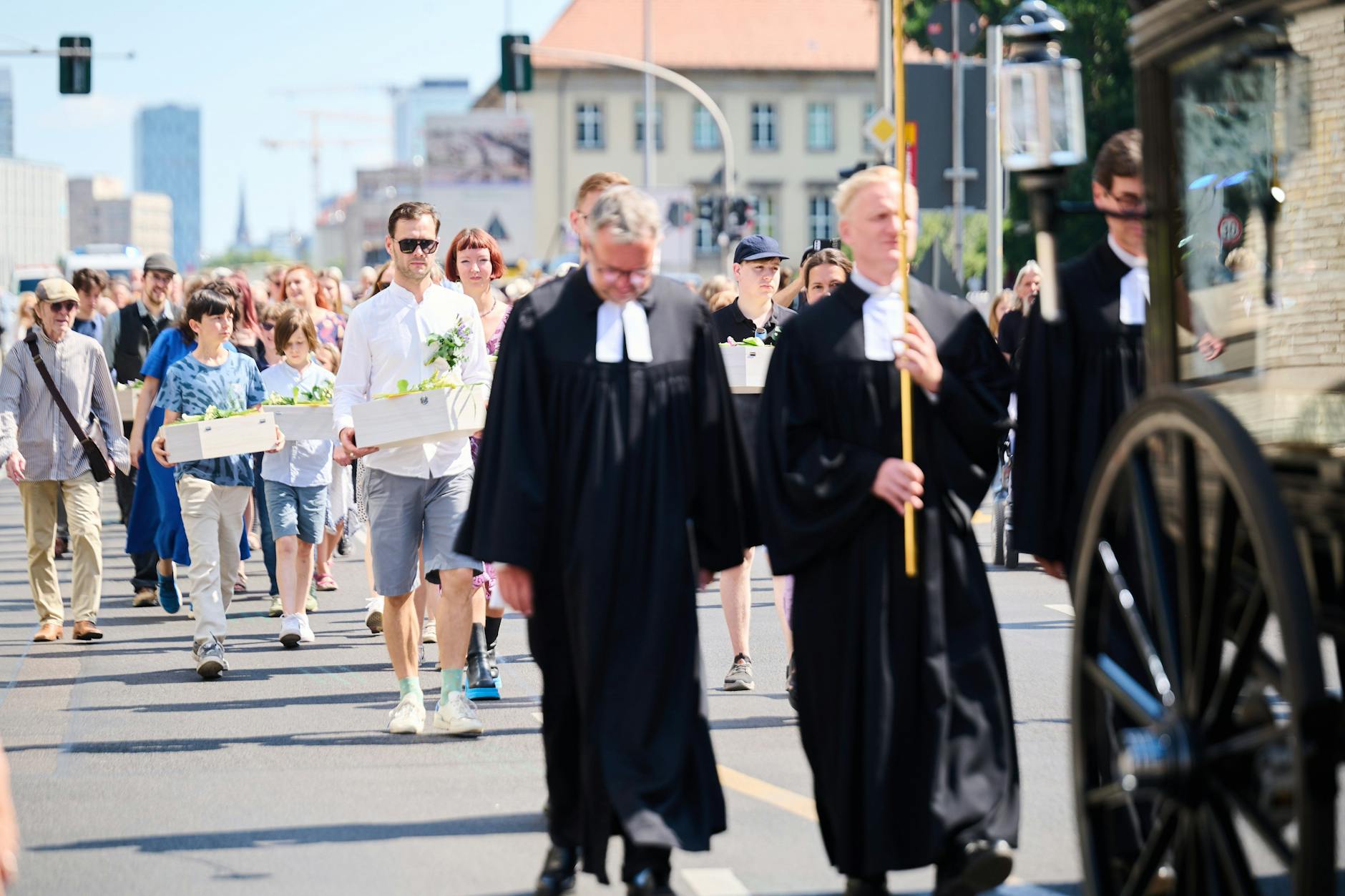 Berlin: Kinder und Erwachsene tragen die Gebeine der ersten mittelalterlichen und frühneuzeitlichen Berlinerinnen und Berliner in kleinen Särgen von der Parochialkirche zum Petriplatz.