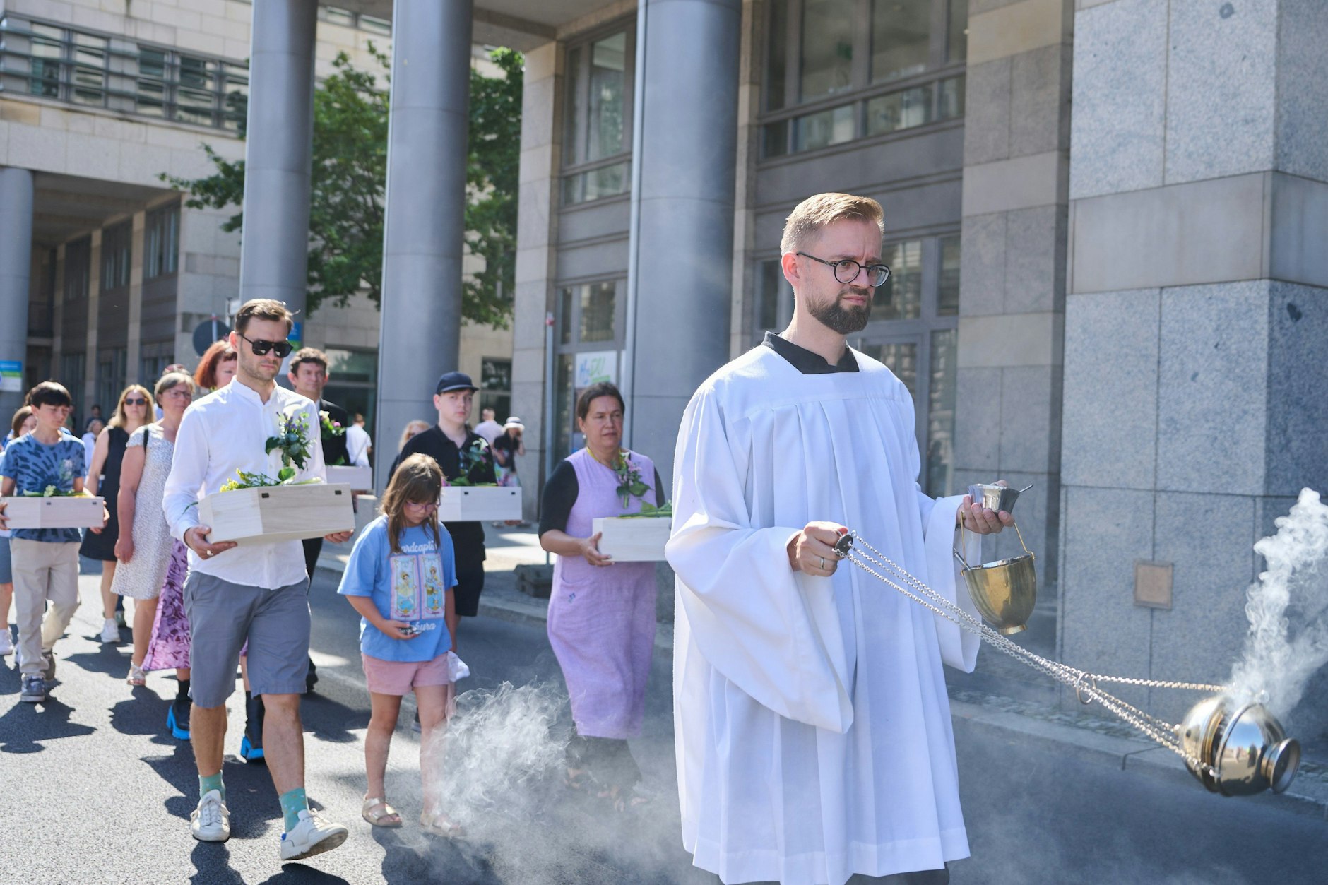 Kinder und Erwachsene tragen die Gebeine der ersten mittelalterlichen und frühneuzeitlichen Berlinerinnen und Berliner in kleinen Särgen von der Parochialkirche zum Petriplatz. 