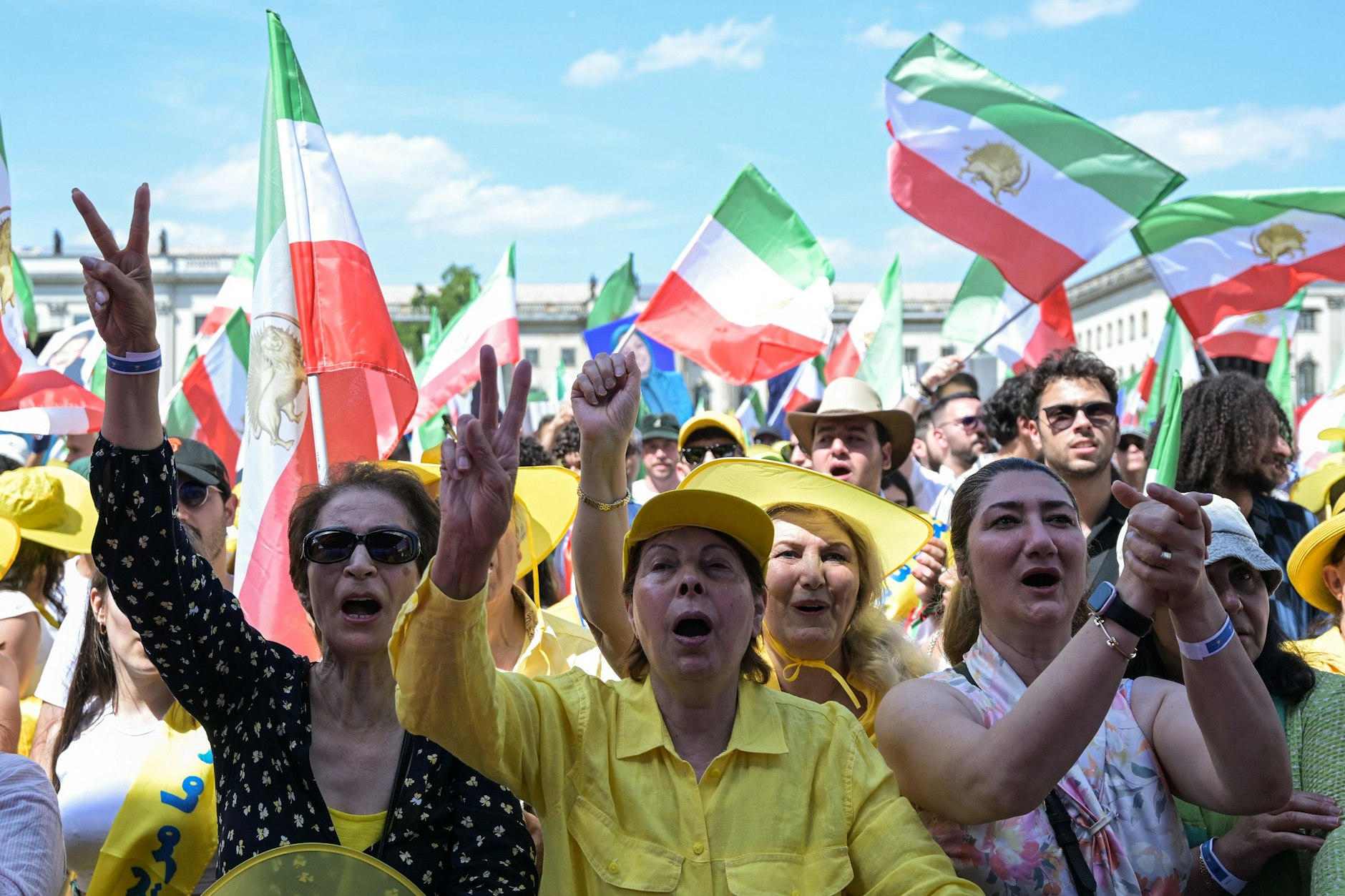 Teilnehmerinnen der Kundgebung am Sonnabend in Berlin zeigen das Victory-Zeichen. Anlässlich der Präsidentenwahl im Iran hat der Nationale Widerstandsrat Iran zu einer Kundgebung aufgerufen - Tausende Demonstranten kamen. 