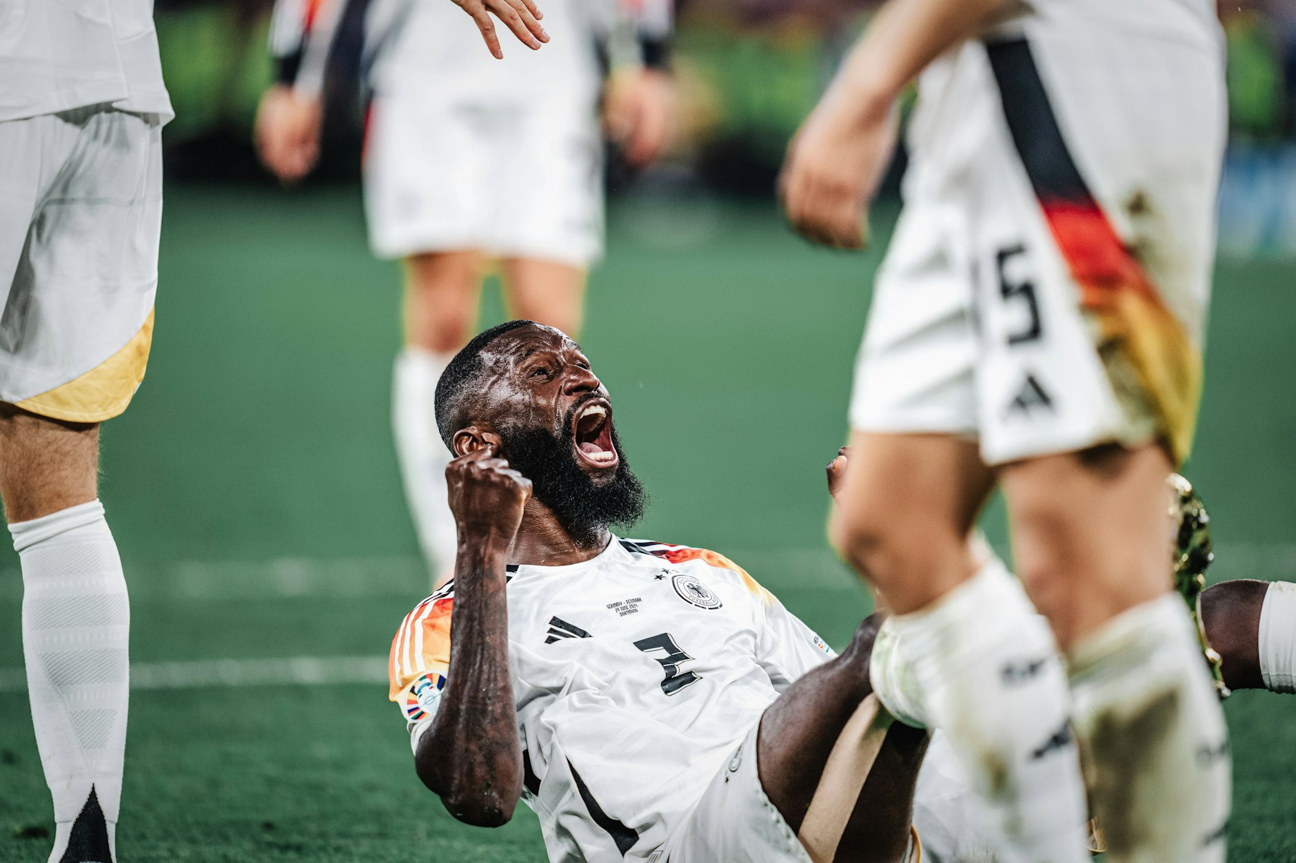 Deutschlands Abwehrboss Antonio Rüdiger jubelt im Sitzen über seine Giganten-Grätsche beim 2:0 gegen Dänemark.