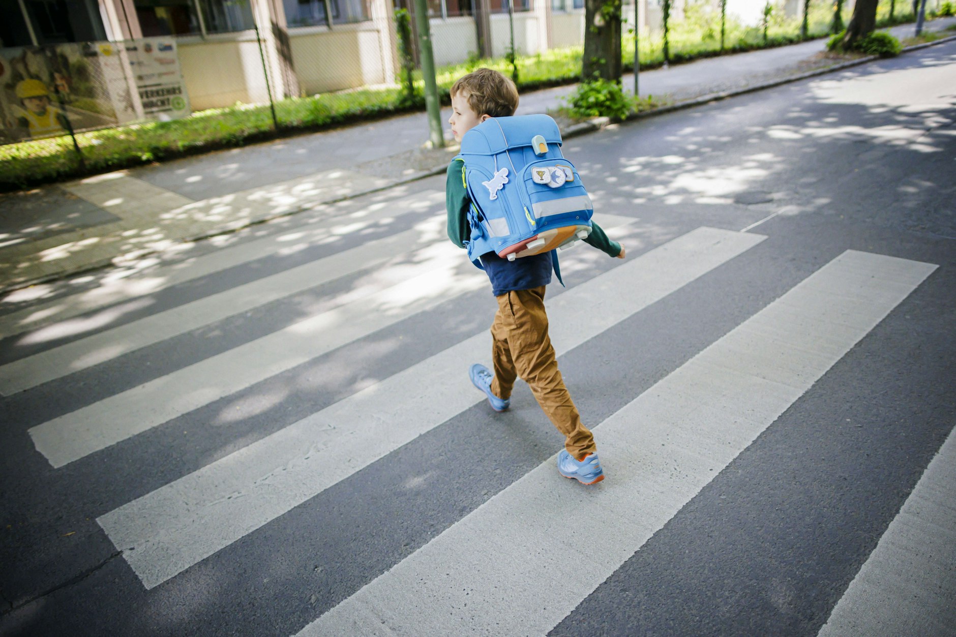 Ein Schulkind überquert einen Zebrastreifen. In Berlin gibt es jetzt weniger Geld für Fußgängerüberwege.