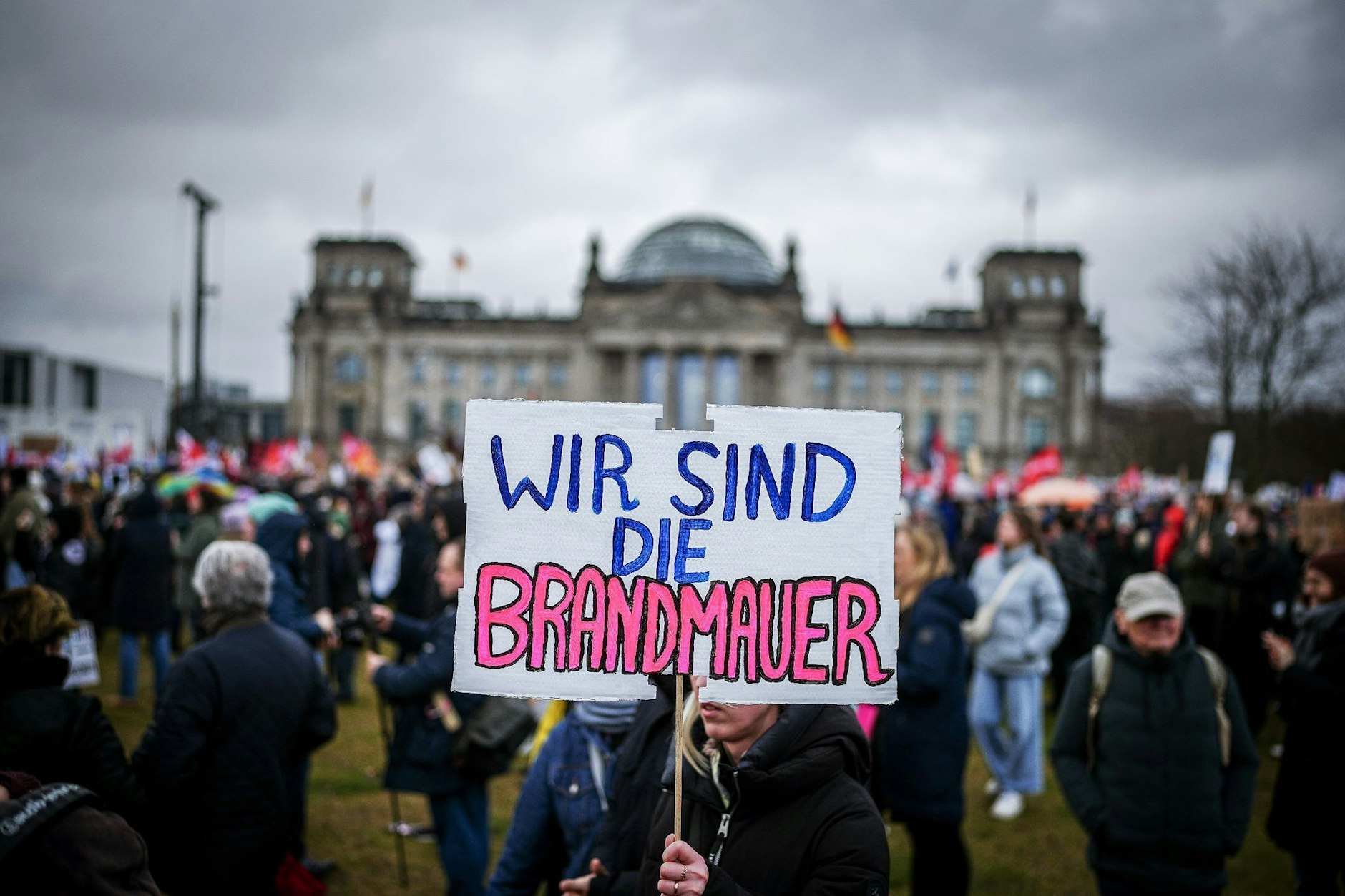 Zahlreiche Menschen nehmen mit Plakaten an der Demonstration eines Bündnisses Wir sind die Brandmauer für Demokratie und gegen Rechtsextremismus teil. 