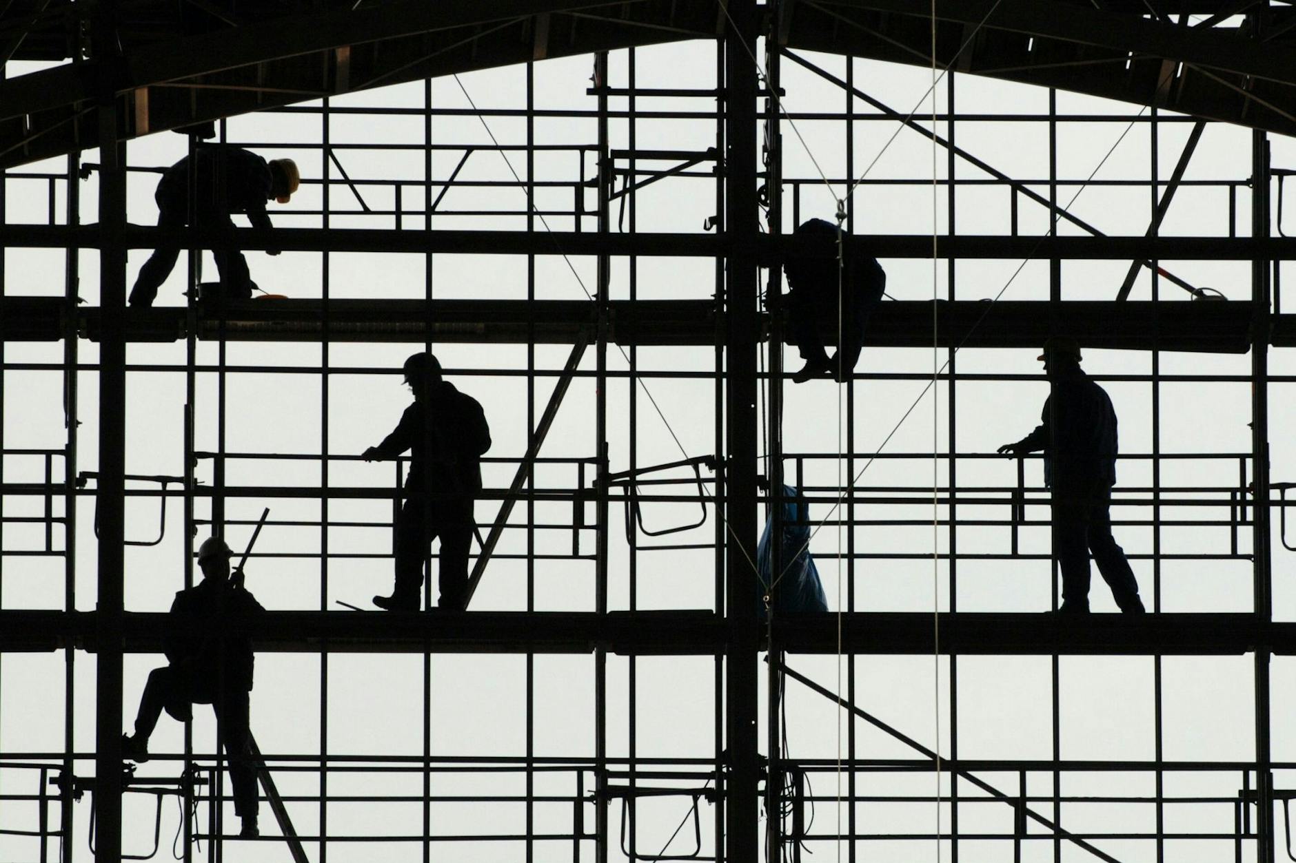 Arbeiter montieren auf einem Gerüst die Glasfassade des Bahnhofs von Frankfurt am Main. 