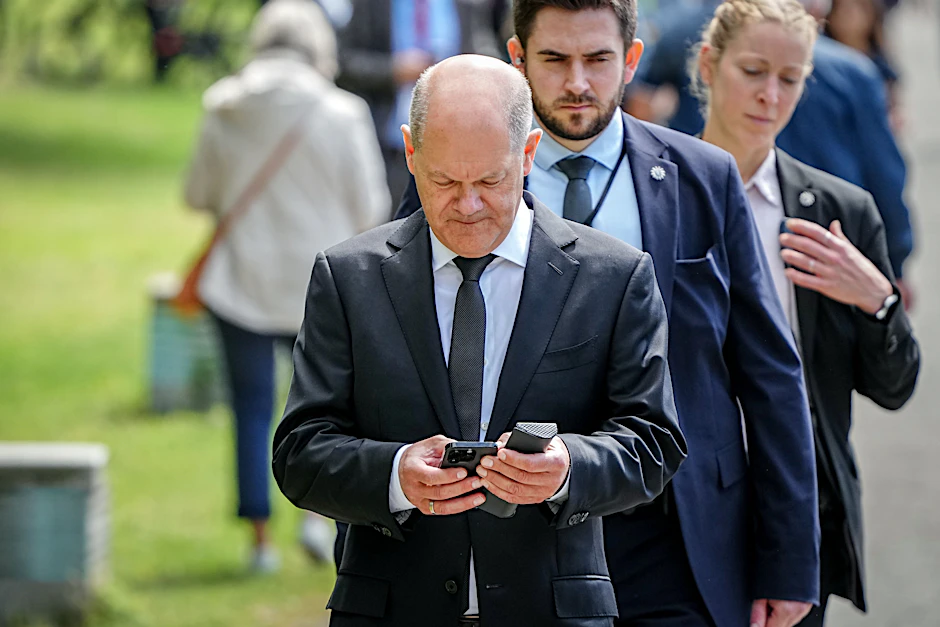 Bundeskanzler Olaf Scholz (SPD) schaut auf sein Handy. Nach eigenen Angaben kommuniziert er täglich mit Emmanuel Macron.