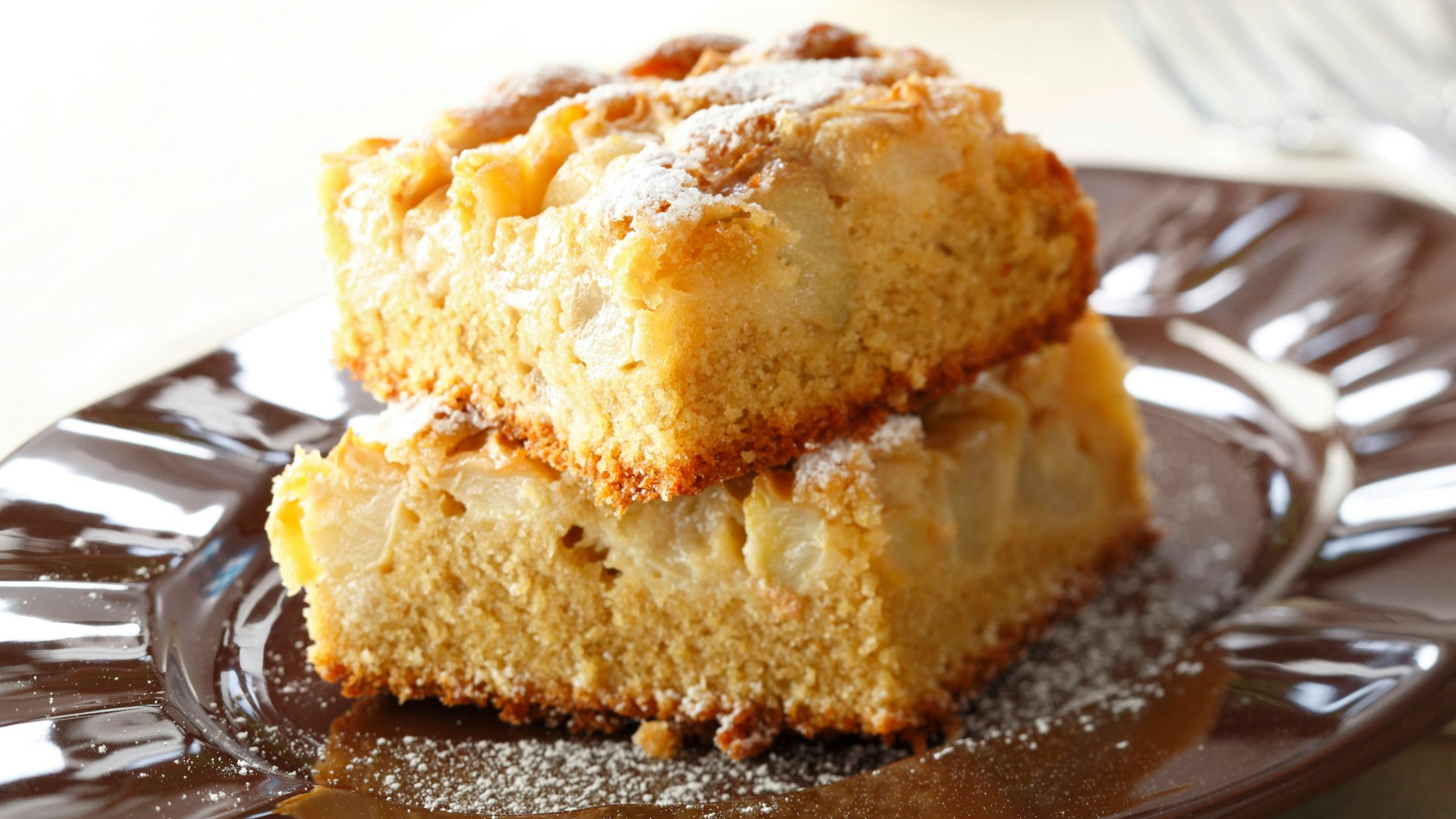 Um das Rezept für Apfelkuchen vom Blech zu vollenden, können Sie etwas Puderzucker über die Kuchen-Schnitten streuen.