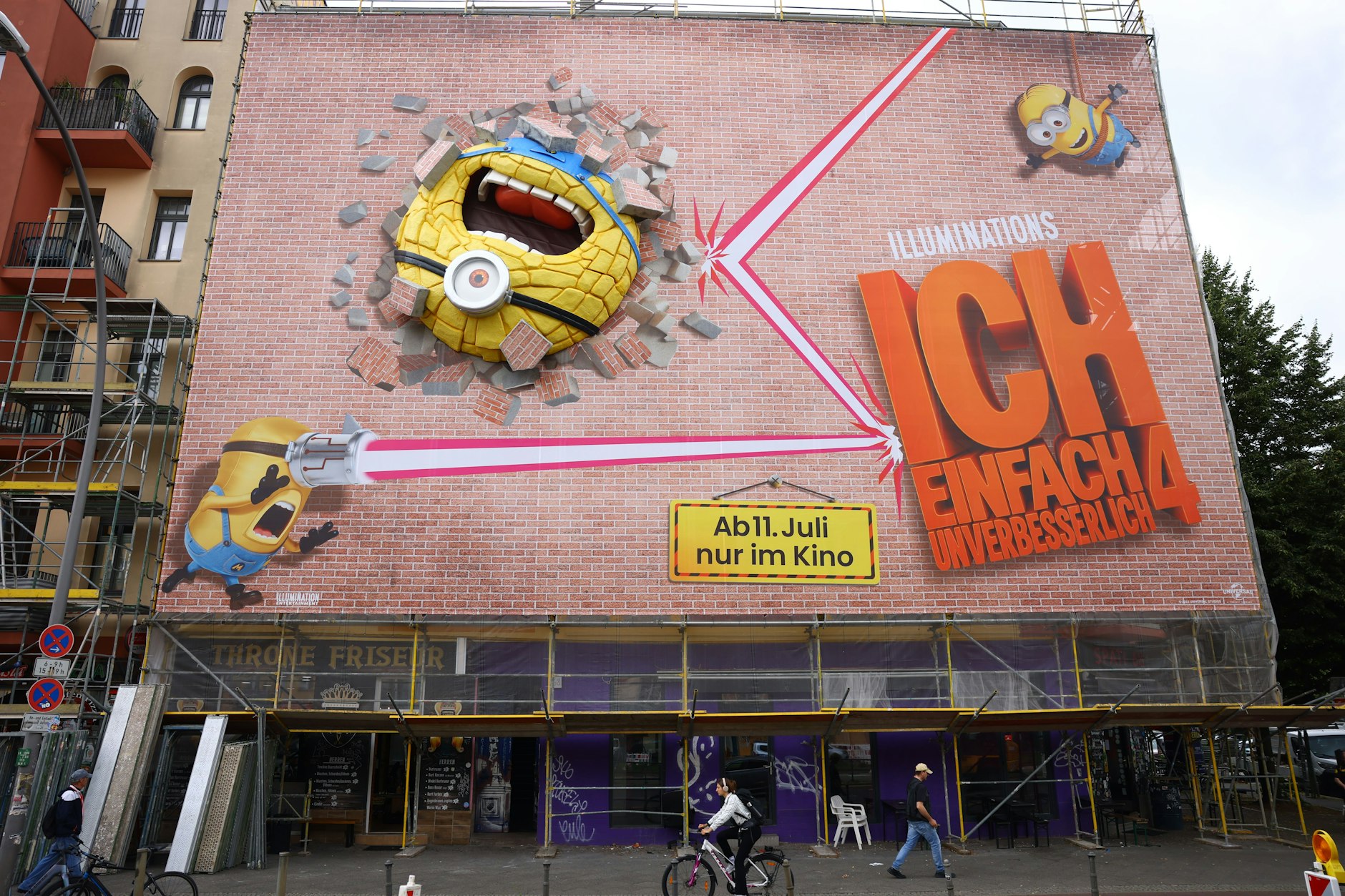 In der Danziger Straße 68 leben Menschen monatelang hinter einem gigantischen Werbeplakat. Der Minion hängt erst seit zwei Tagen, zuvor wechselten sich seit Dezember 2023 verschiedene andere Werbebanner ab.