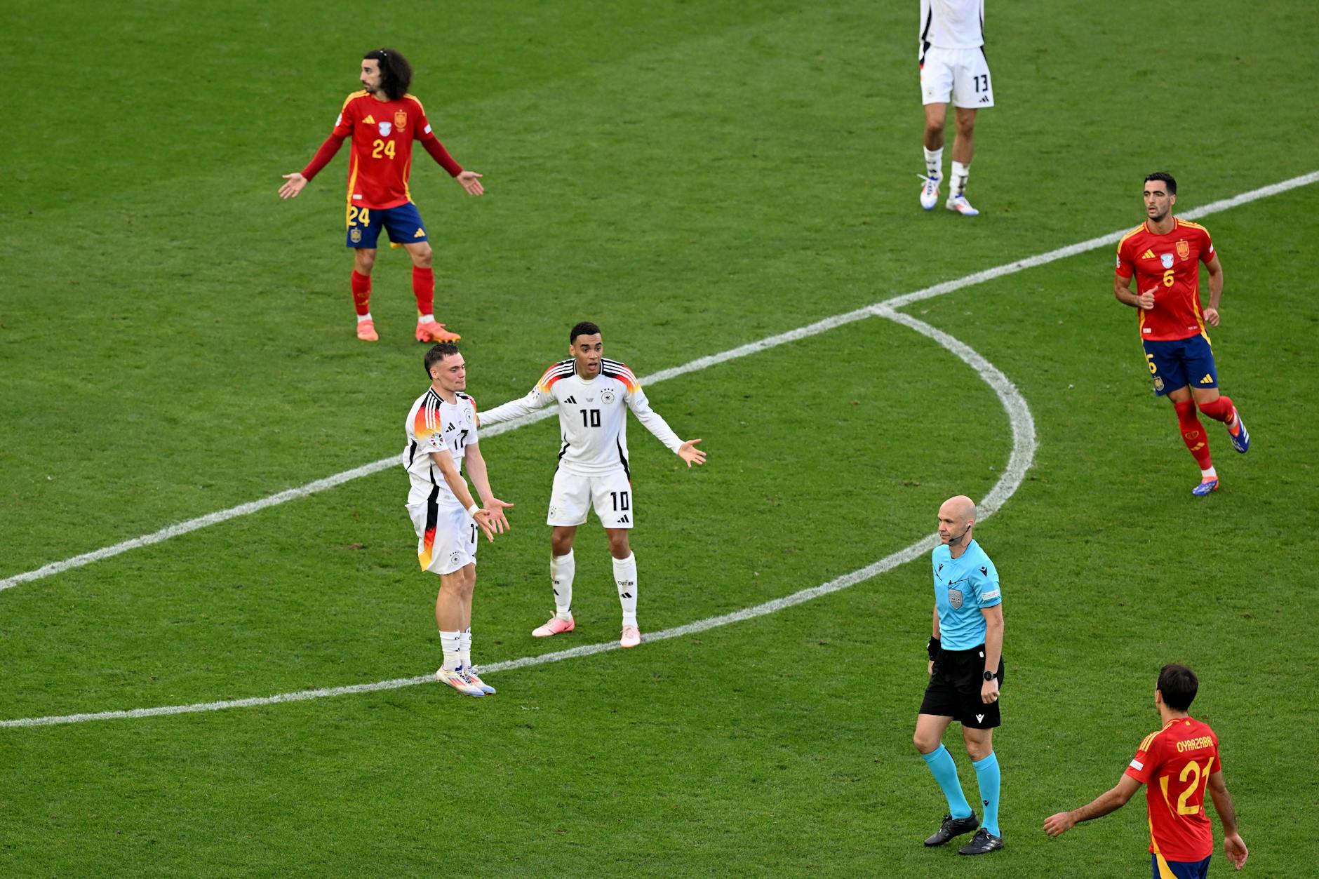 Jamal Musiala und Florian Wirtz reklamierten nach einem Handspiel von Spaniens Marc Cucurella bei Schiedsrichter Anthony Taylor aus England. Doch der wollte sich nicht einmal die Videosequenz anschauen. Grund genug für viele Fans eine Wiederholung des EM-Viertelfinales zu fordern.