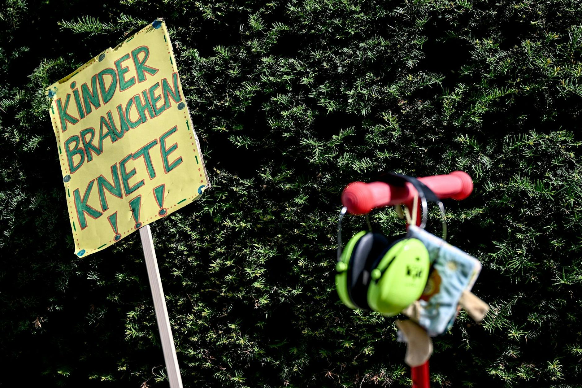 Vor dem Berliner Abgeordnetenhaus steht ein Schild mit der Aufschrift "Kinder brauchen Knete" bei der Kundgebung streikender Kita-Erzieherinnen.
