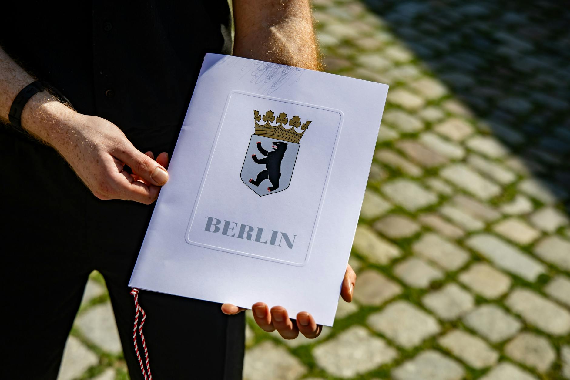 Hier hält ein neuer deutscher Staatsbürger seine Einbürgerungsurkunde in die Hände vor der Zentrale Einbürgerungsstelle des Landesamtes für Einwanderung in Berlin. (Archivbild)