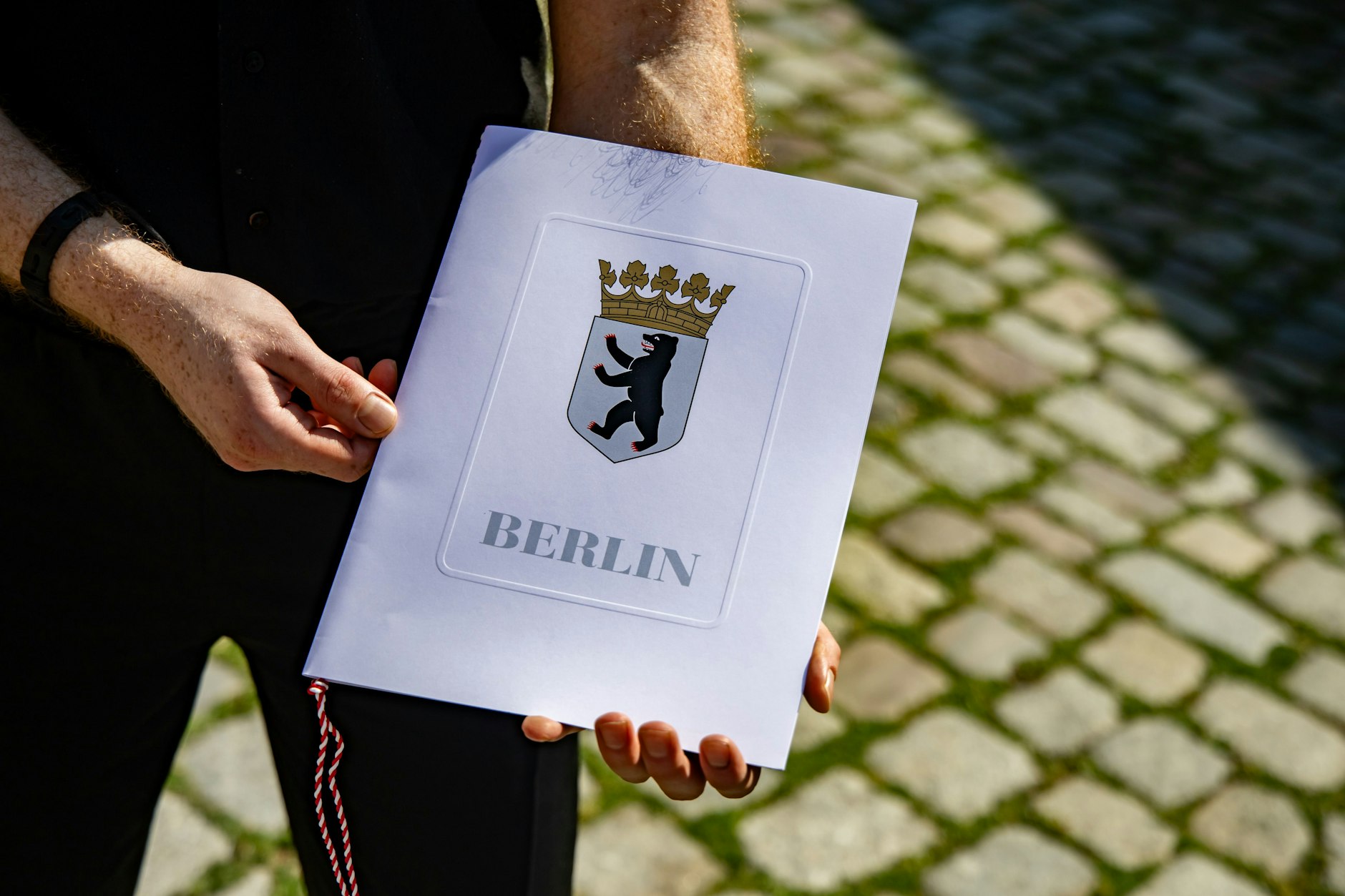 Hier hält ein neuer deutscher Staatsbürger seine Einbürgerungsurkunde in die Hände vor der Zentrale Einbürgerungsstelle des Landesamtes für Einwanderung in Berlin. (Archivbild) 