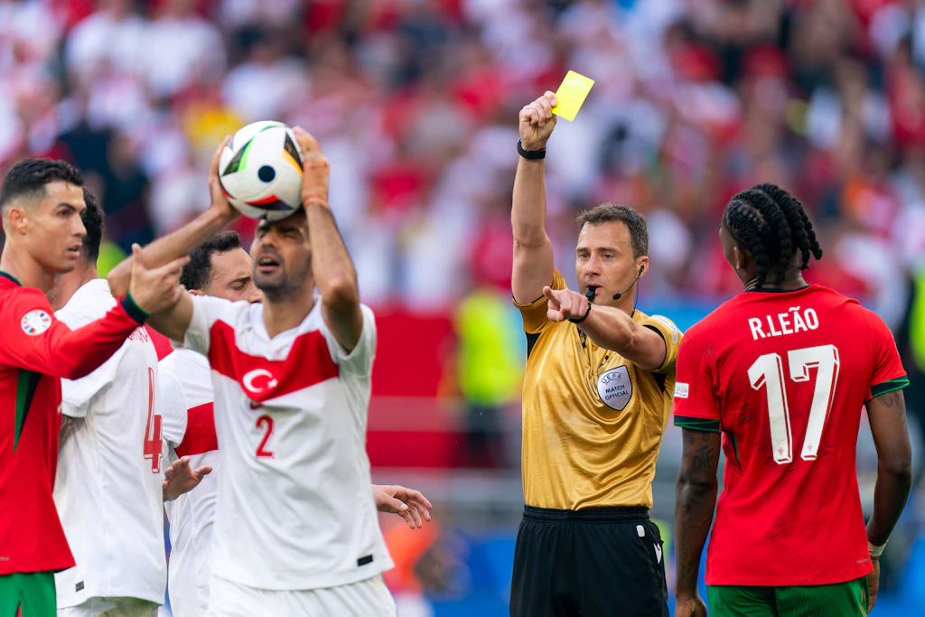Türkeis Zeki Celik (l.) kann nicht ganz nachvollziehen, warum ihm Felix Zwayer die Gelbe Karte zeigt.
