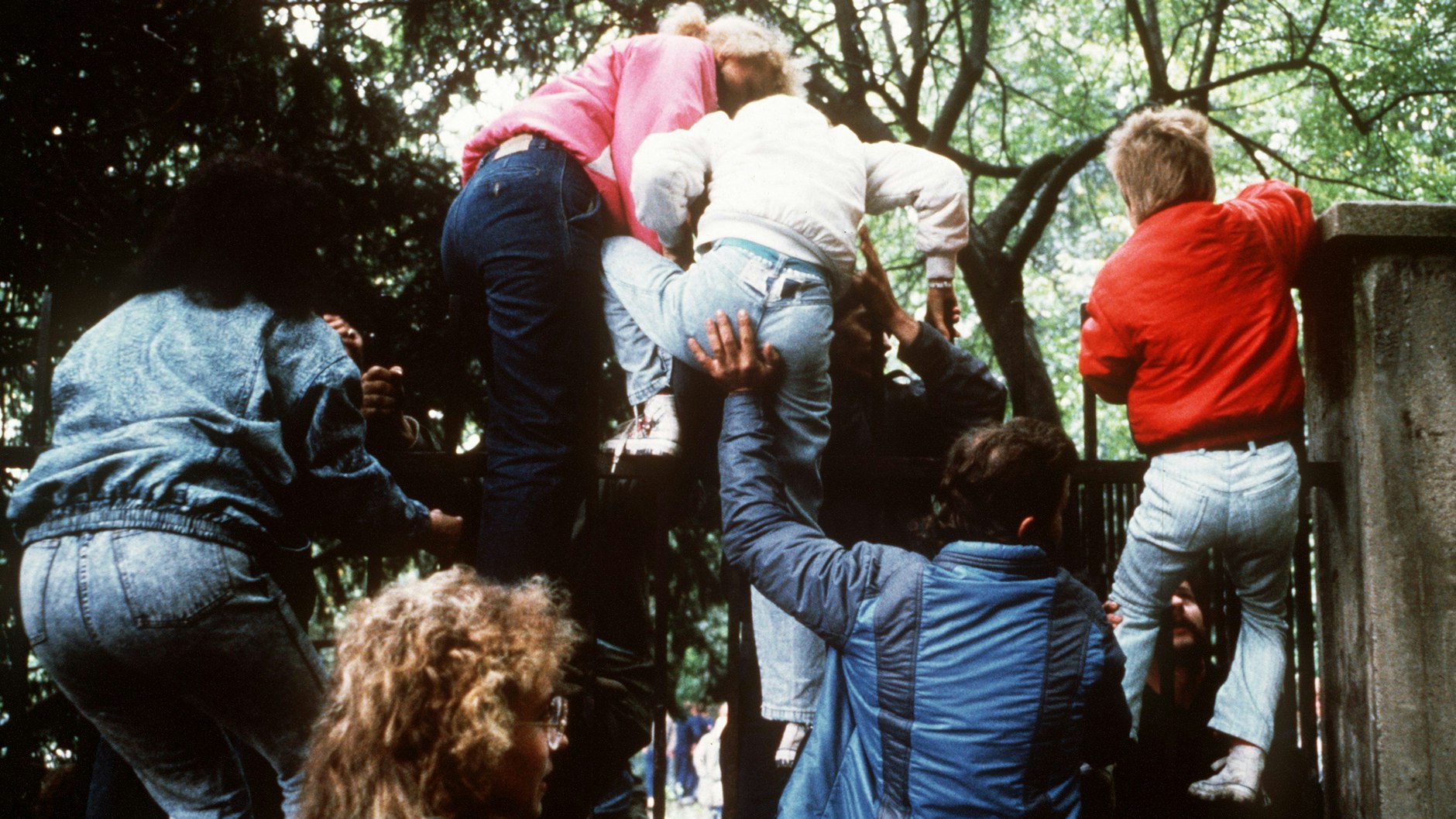 29. September 1989 DDR-Bürger klettern mit ihren Kindern über den Zaun der bundesdeutschen Botschaft in Prag.&nbsp;