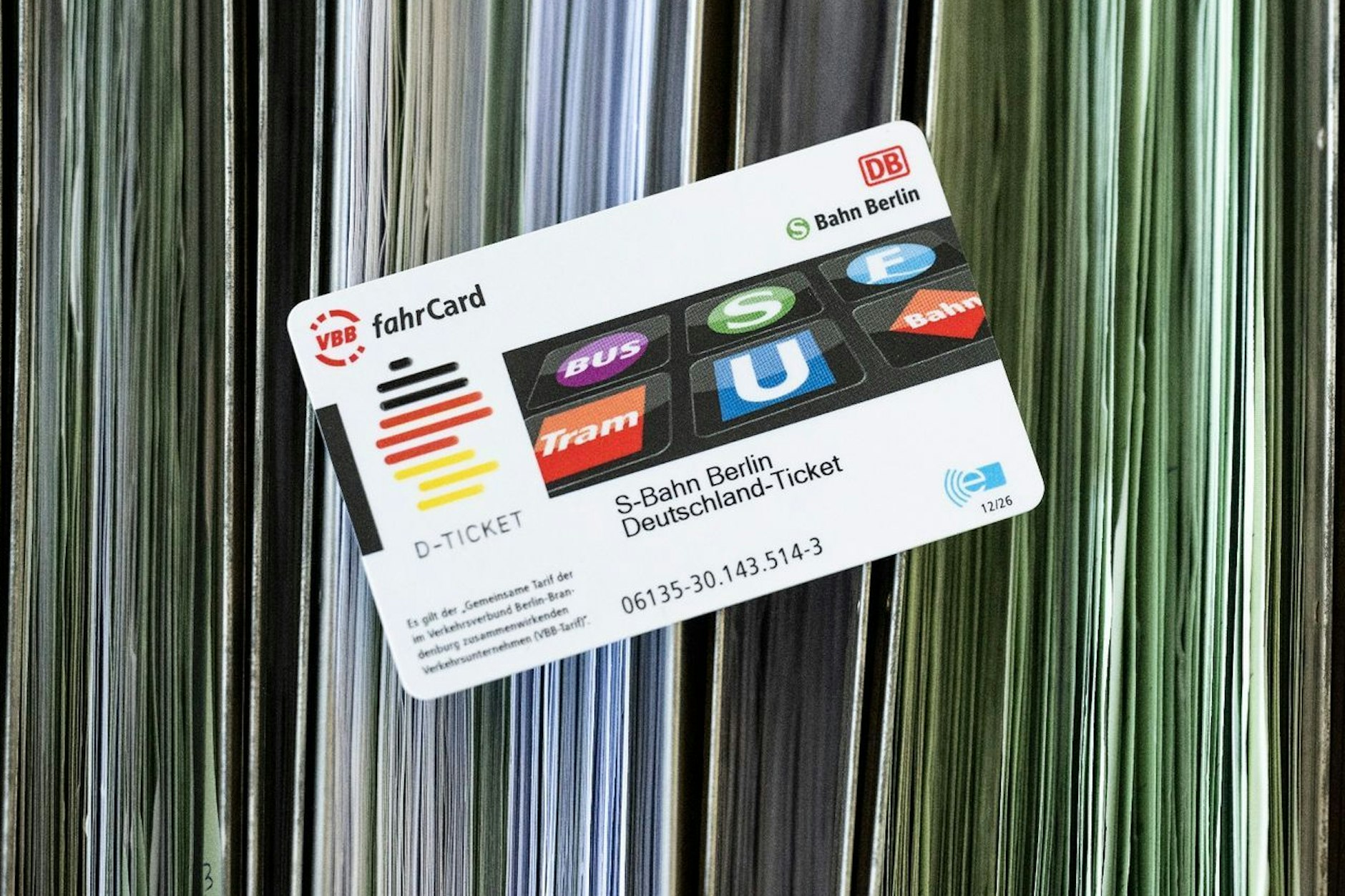 Eine Deutschlandticket-Chipkarte liegt auf sortierten Abo-Anträgen bei der BVG. 