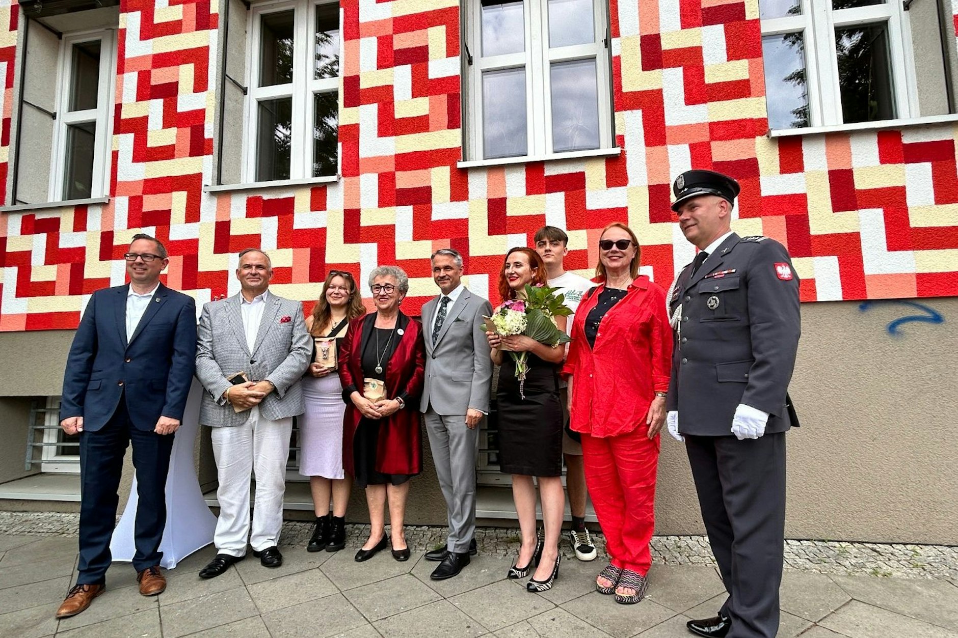 Vor dem neuen Wandbild zu 80 Jahre Warschauer Aufstand mit Bezirksbürgermeister Igel, Pjotr Ostrowski, beteiligten Jugendlichen, Anita Baranowska-Koch, S.E. Dariusz Pawłoś, Maria Michoń und weitere.