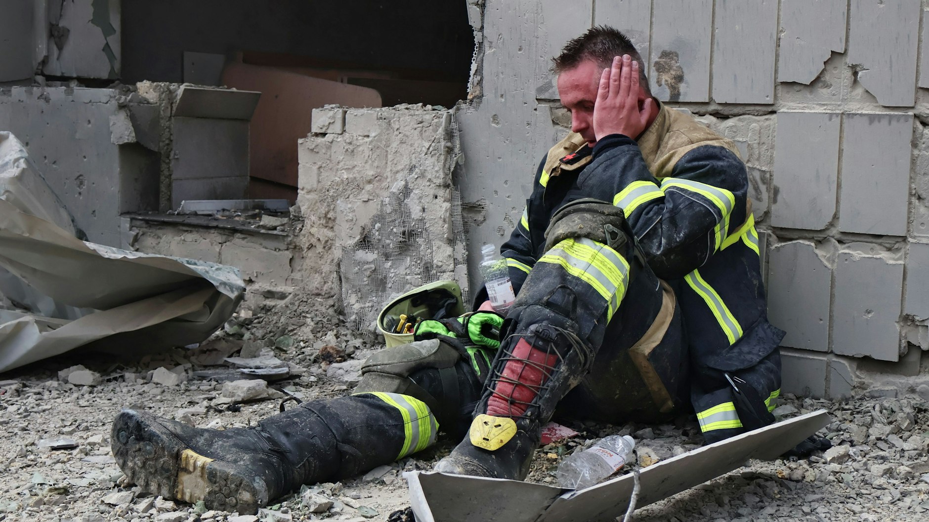 Erschöpft sitzt dieser Feuerwehrmann in Trümmern bei dem zerstörten Kinderkrankenhaus in Kiew.