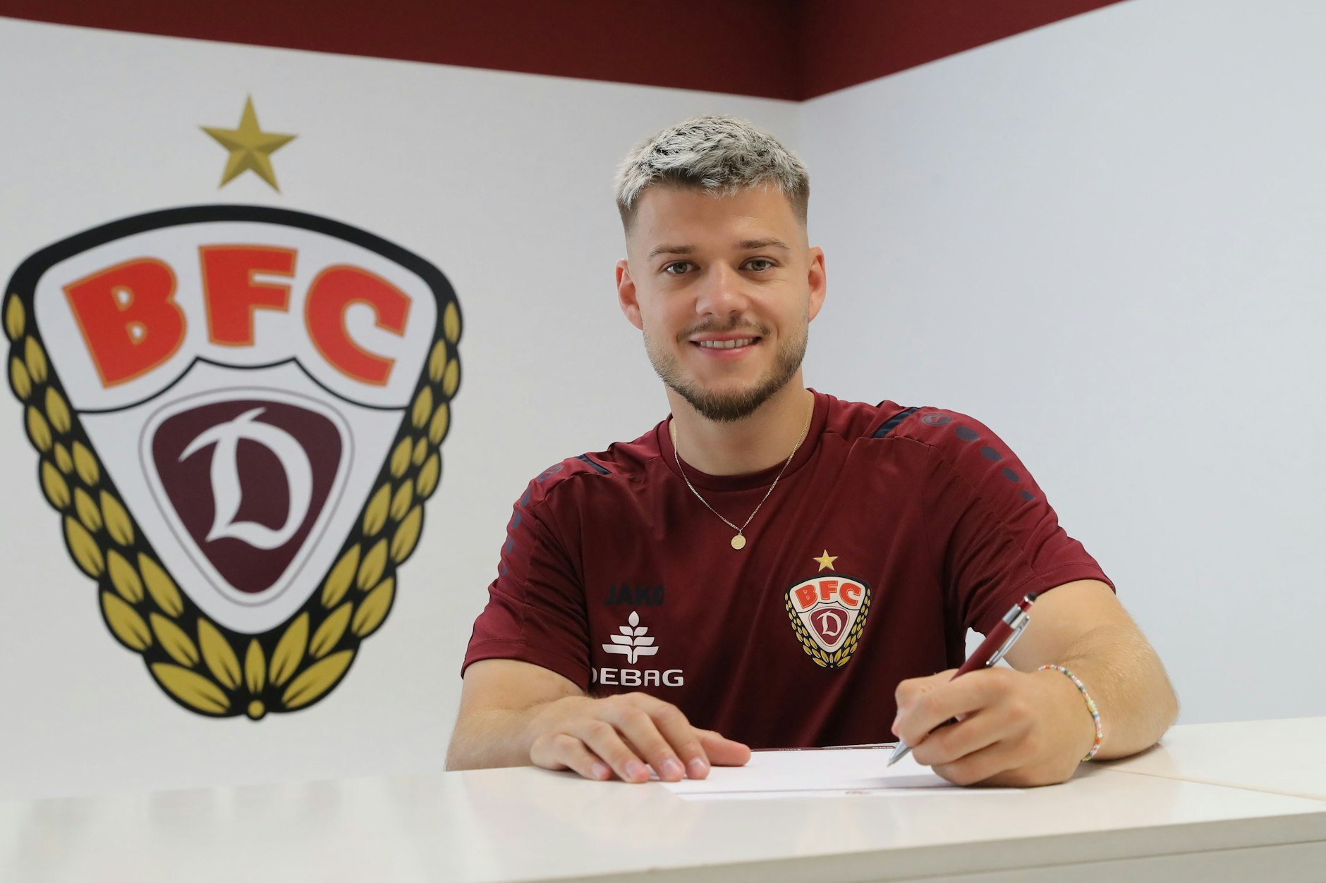 Der Moment, der den BFC Dynamo froh macht: Ivan Knezevic setzt die Unterschrift unter den Vertrag beim Regionalligisten.